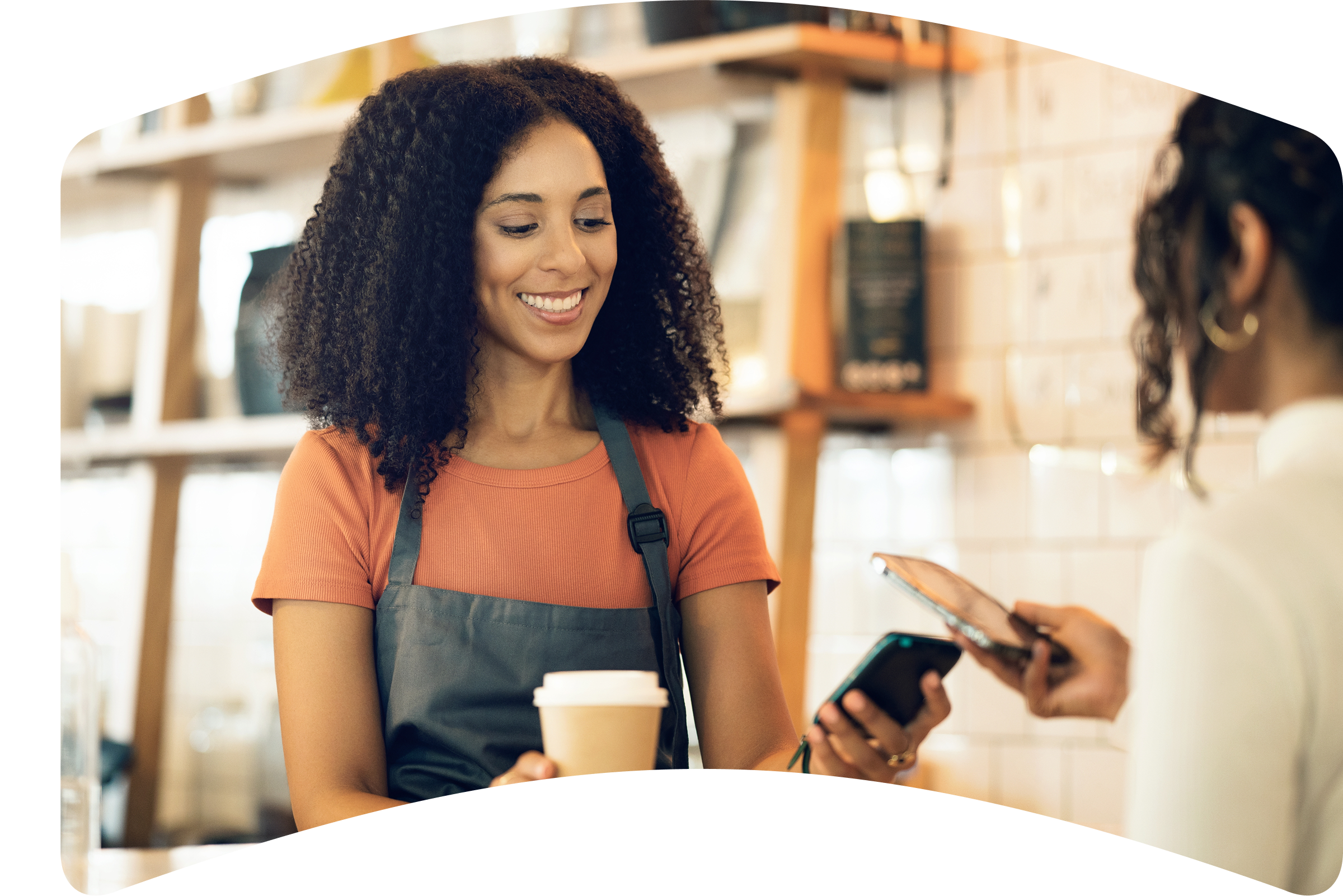 a woman in an apron is smiling while holding a cup of coffee