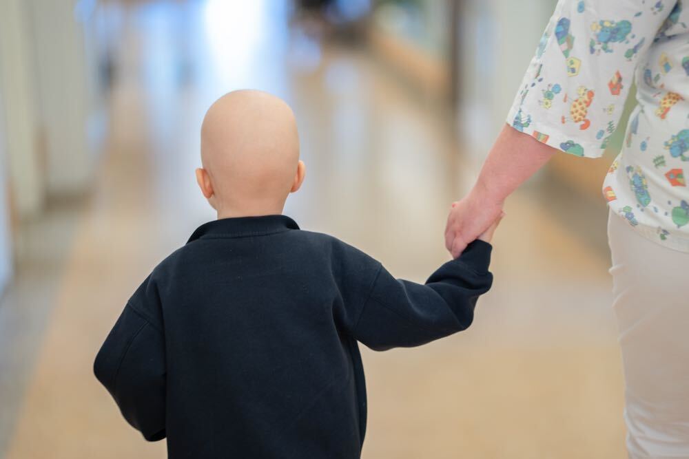 Sunset over a city harbor with floating structures and a distant skyline.