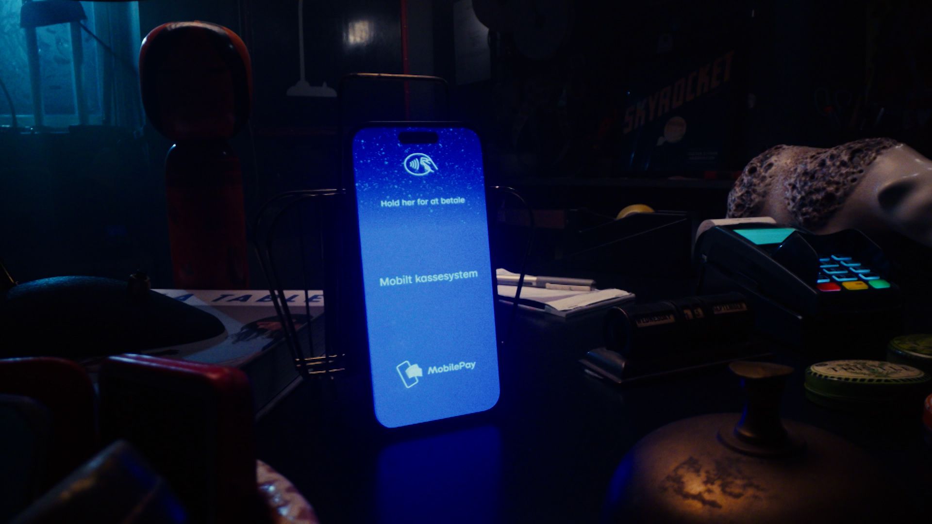 a cell phone is sitting on a table next to a credit card machine .
