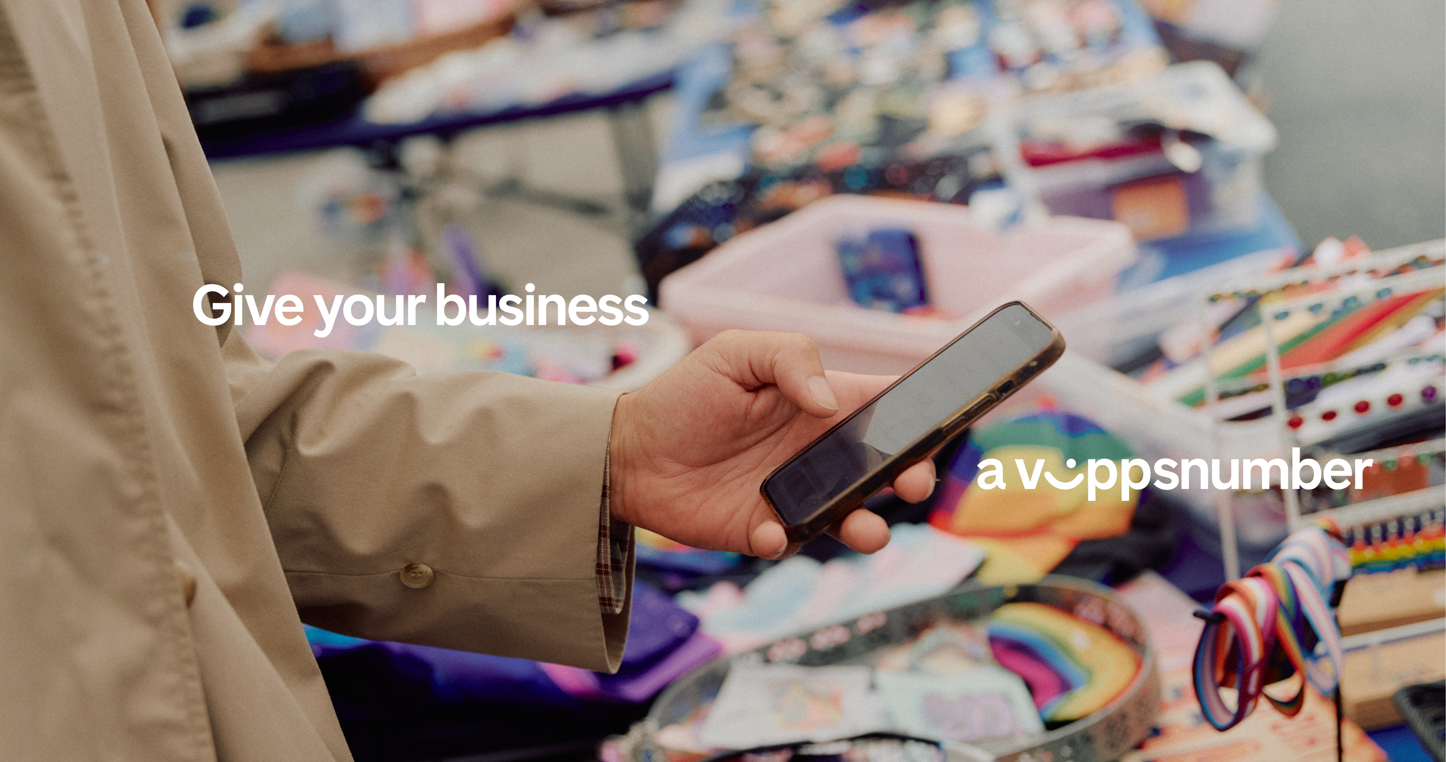 Person holding a smartphone at a market stall with text: "Give your business a Vippsnumber."