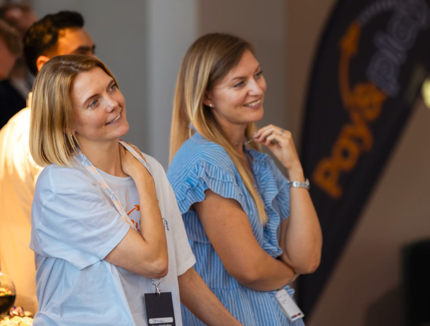 Two smiling women at an event looking to the right.
