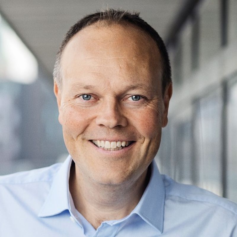 Smiling man in a light blue shirt.