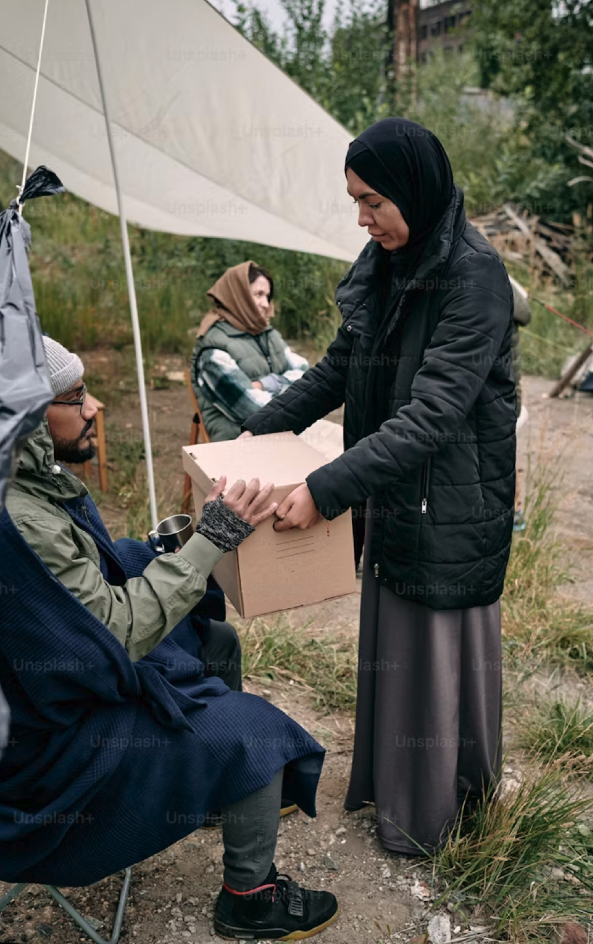 An image of a woman giving a cardboard box to a man