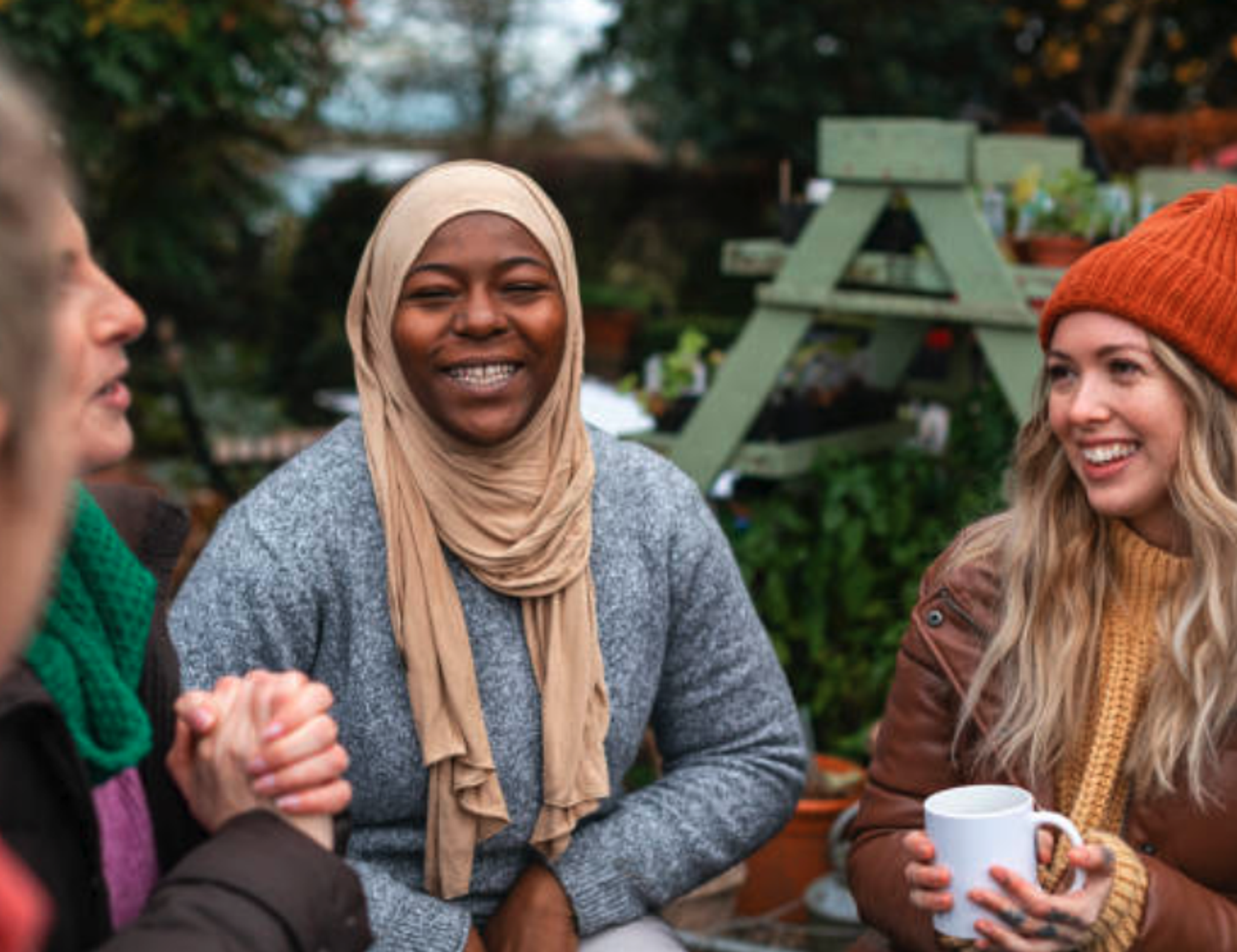 A group of women smiling and chatting over coffee