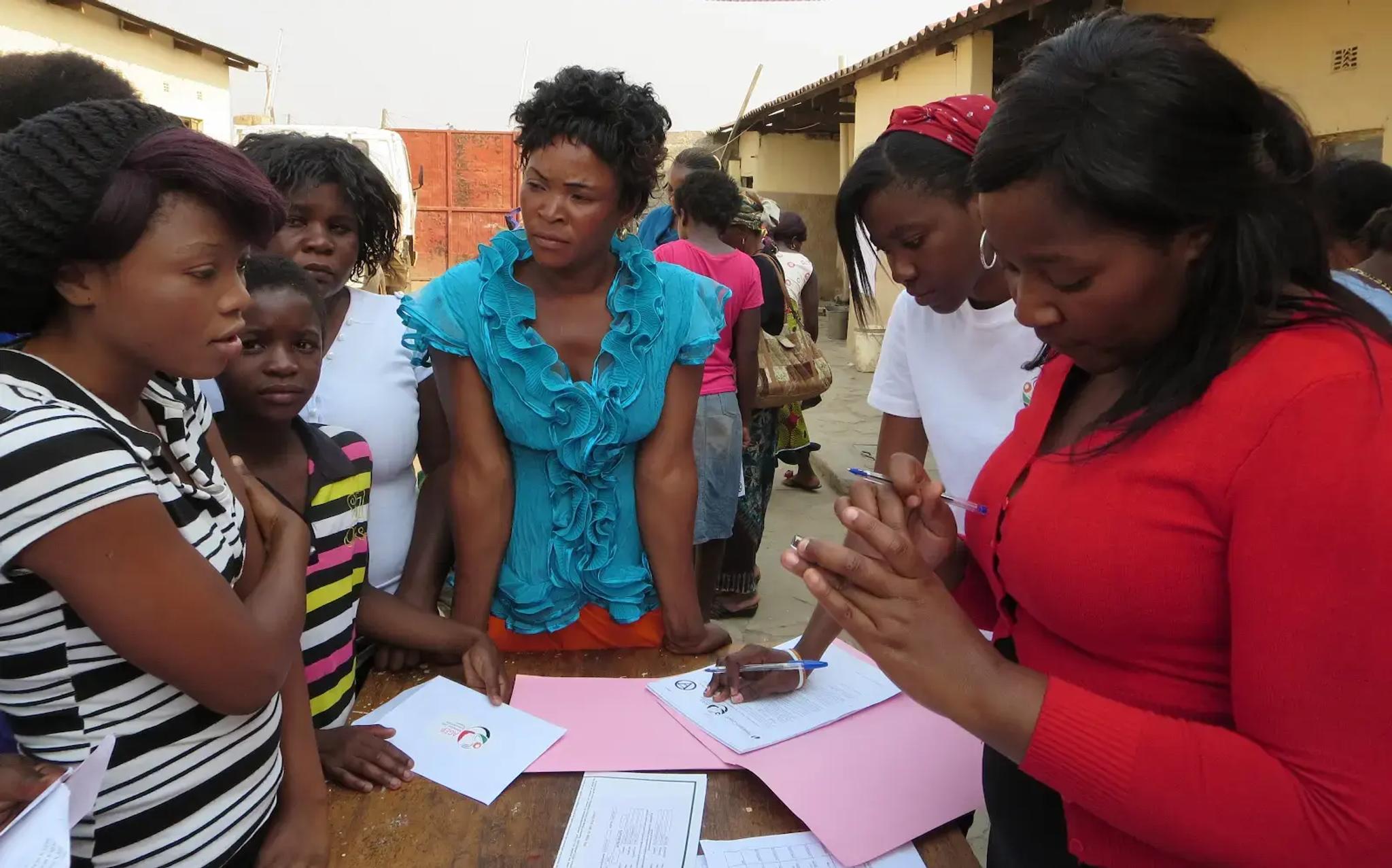 Women discussing something at a table with paperwork