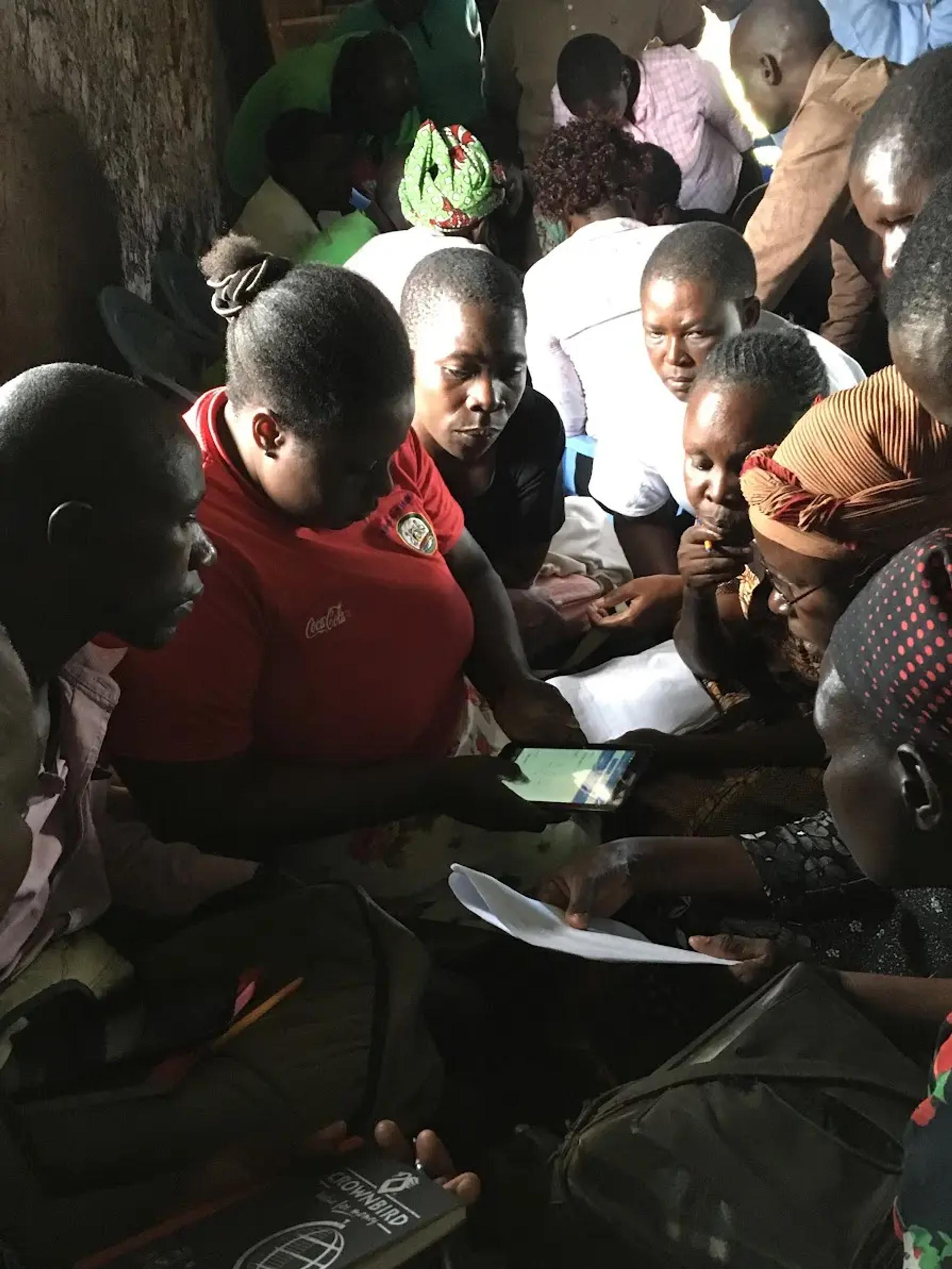 A group of people working together with a phone and papers