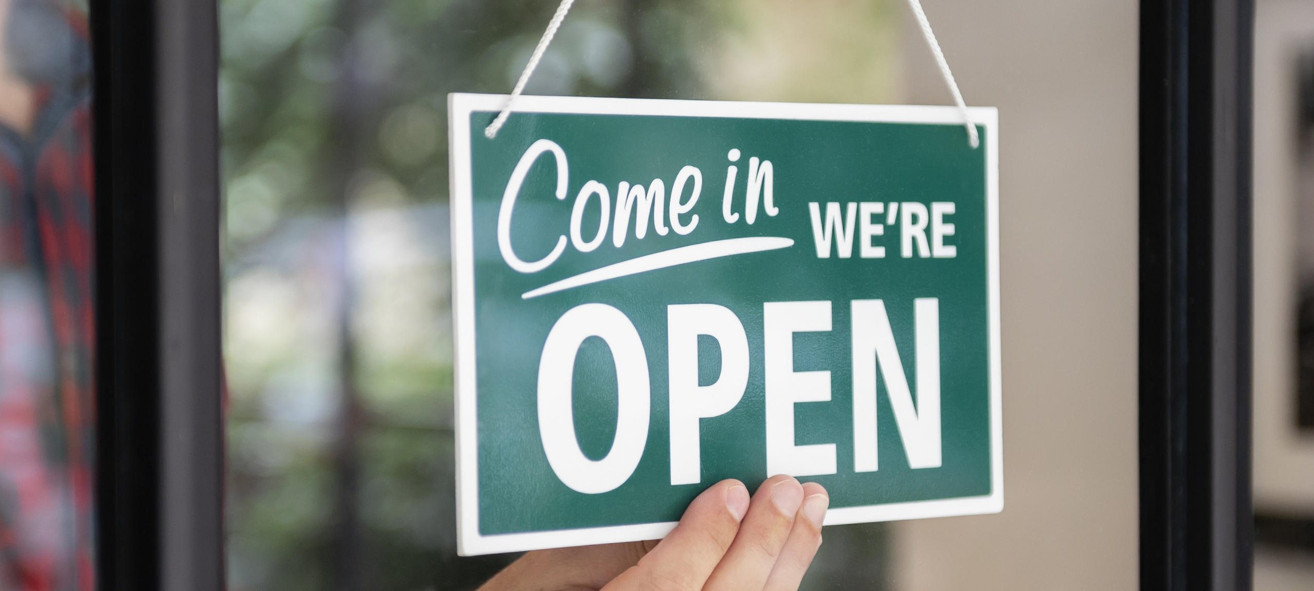 A sign inside a shop that reads, "Come in, we're open"
