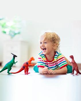A boy playing with toy dinosaurs