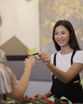 A florist accepting a debit card from a customer