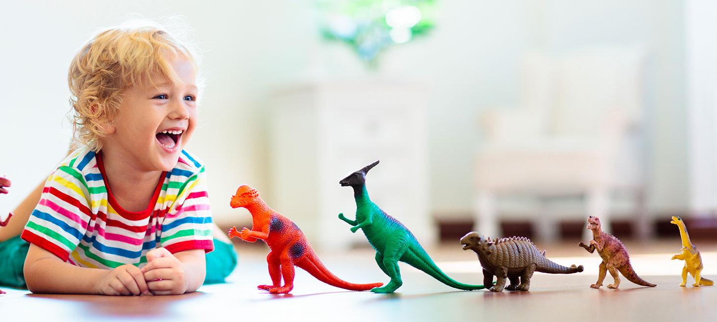 A boy playing with toy dinosaurs