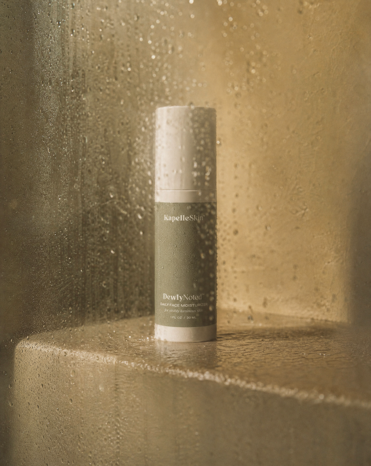 A rain-covered KapelleSkin bottle in a softly lit stone setting.