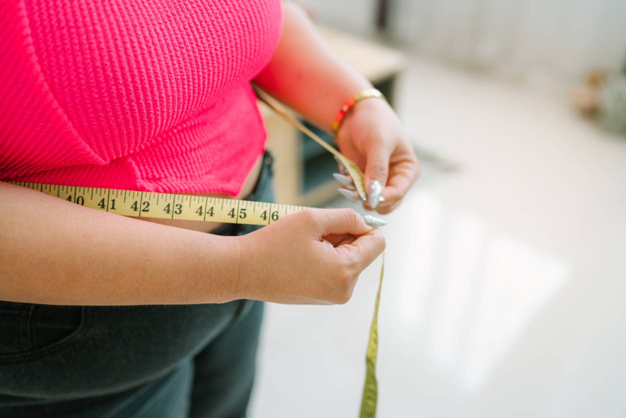 Overweight woman with measuring tape