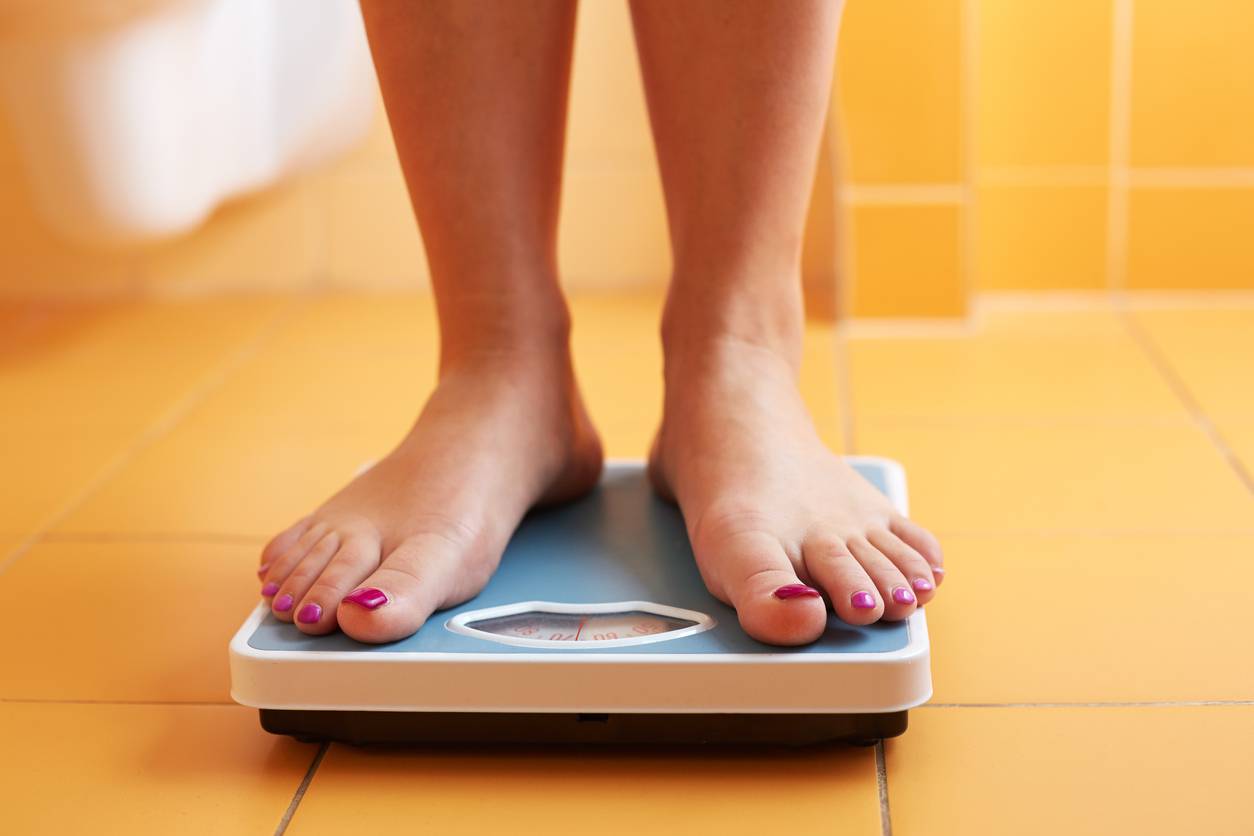 Overweight person standing on scales