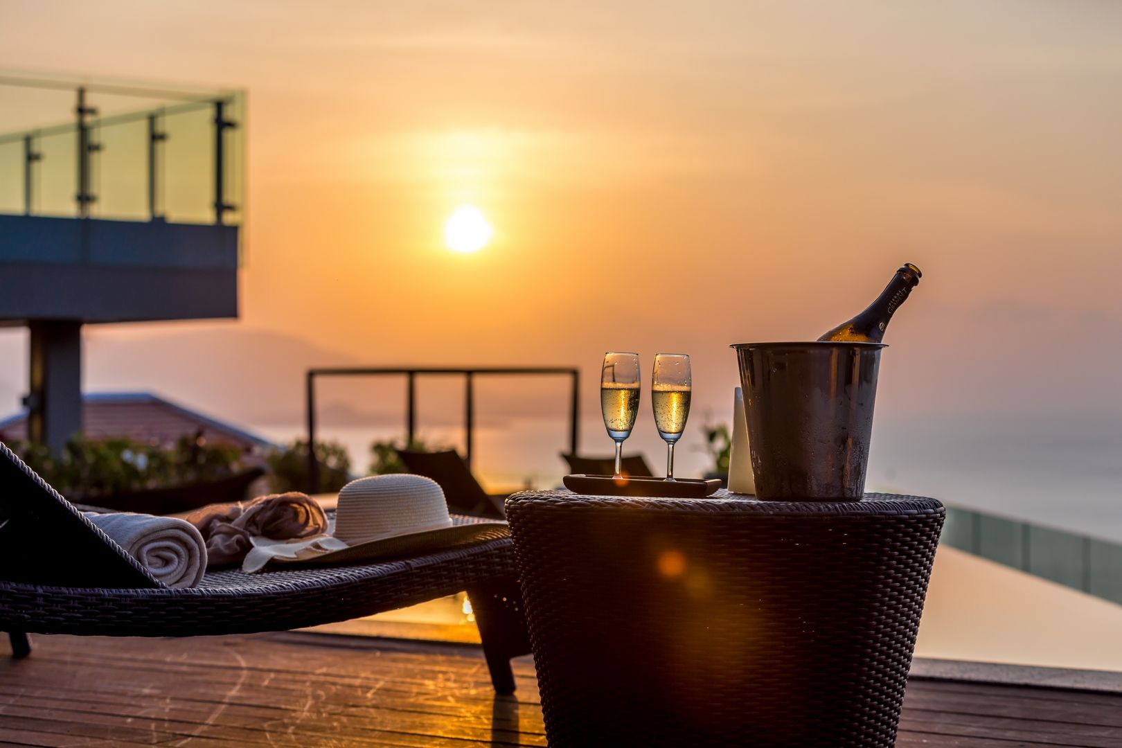 Champagne glasses and a bottle on the pool terrace at sunset