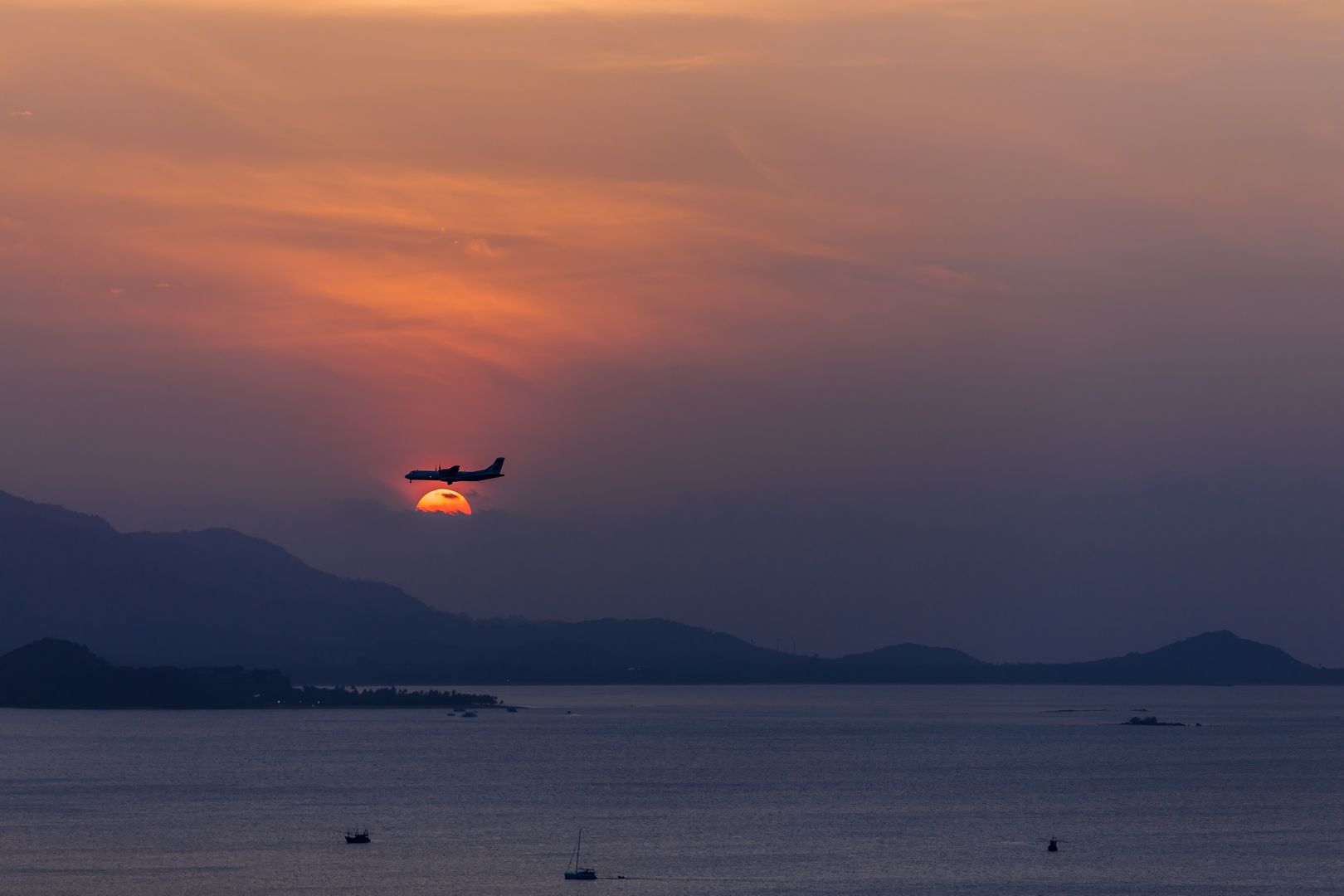 Aeroplane coming in to land over Koh Samui at sunset