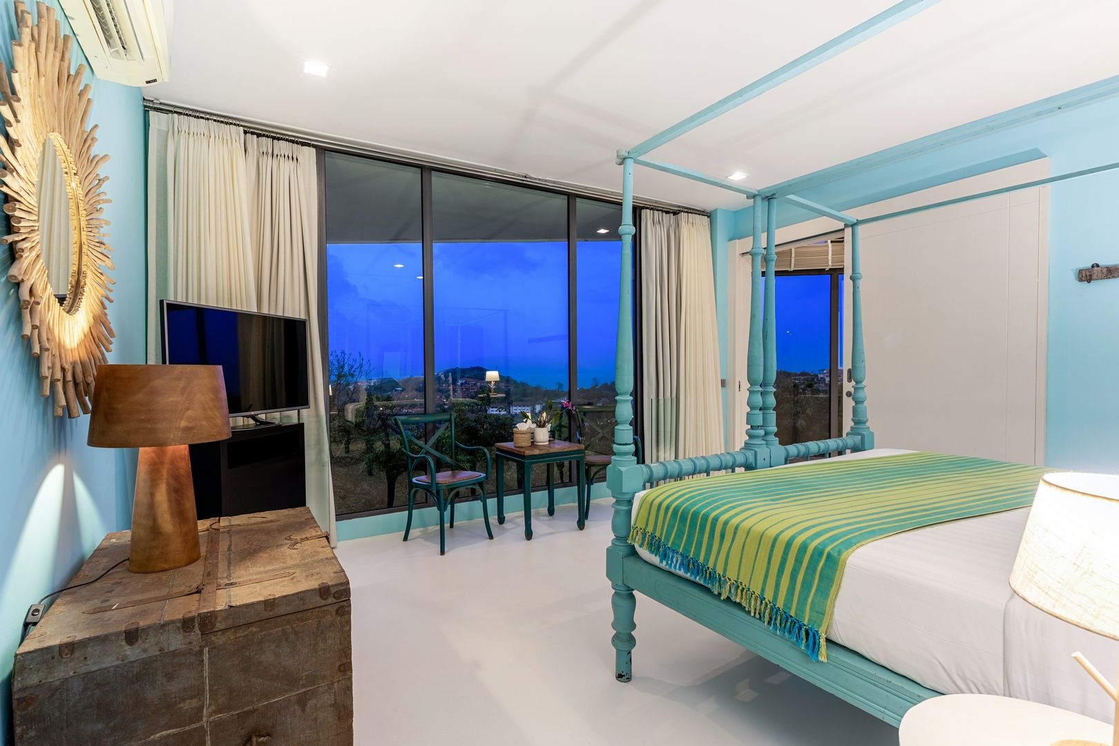 Turquoise Suite with an evening view from its balcony doors