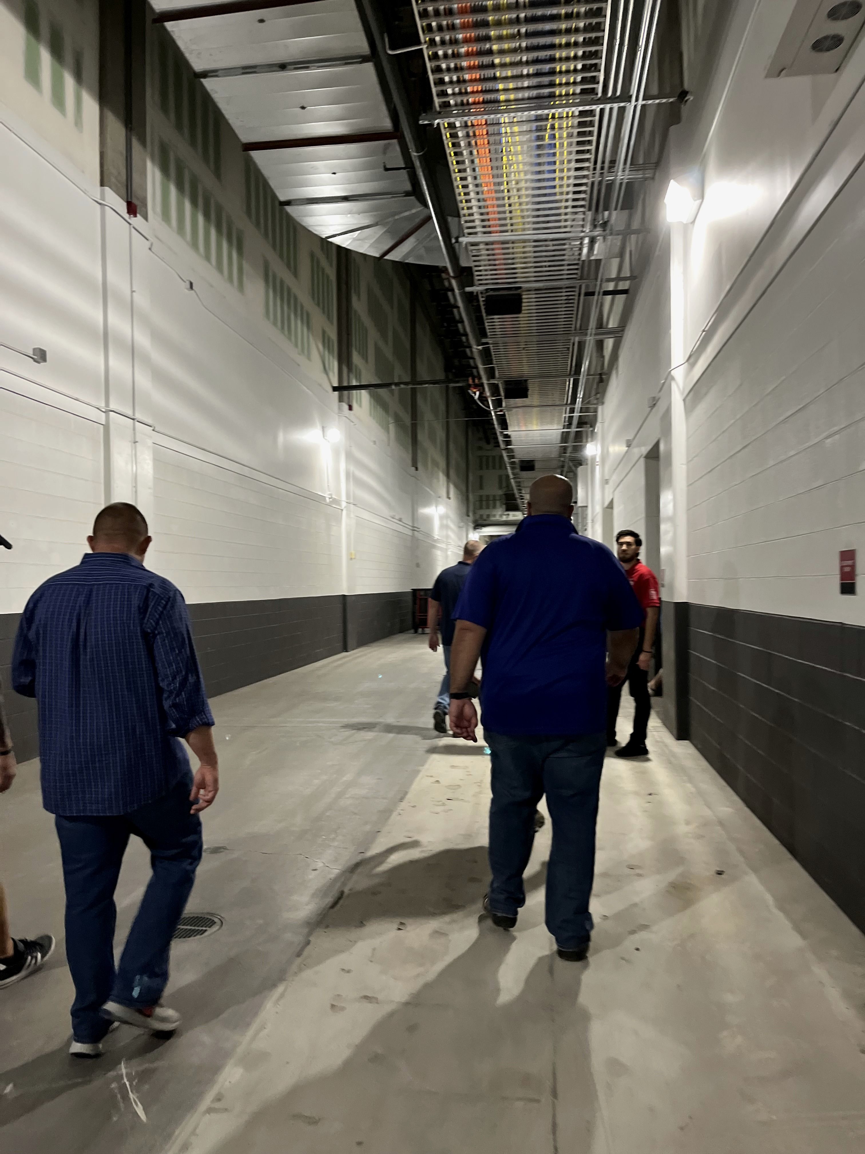Security personnel walking a backstage service corridor
