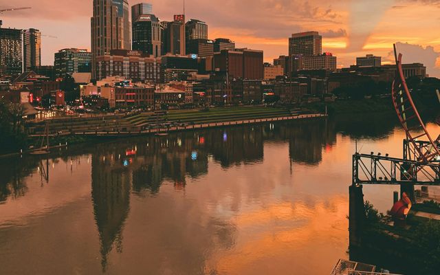 body of water near city buildings during sunset