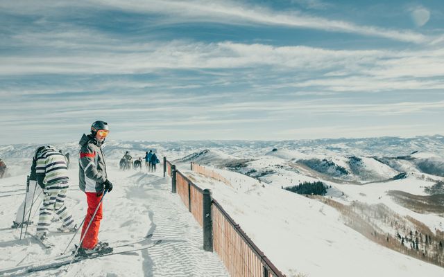 a man standing on top of a snow covered slope