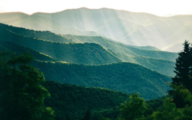 the sun shines through the clouds in the mountains