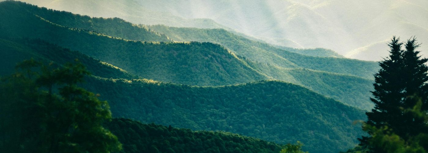 the sun shines through the clouds in the mountains
