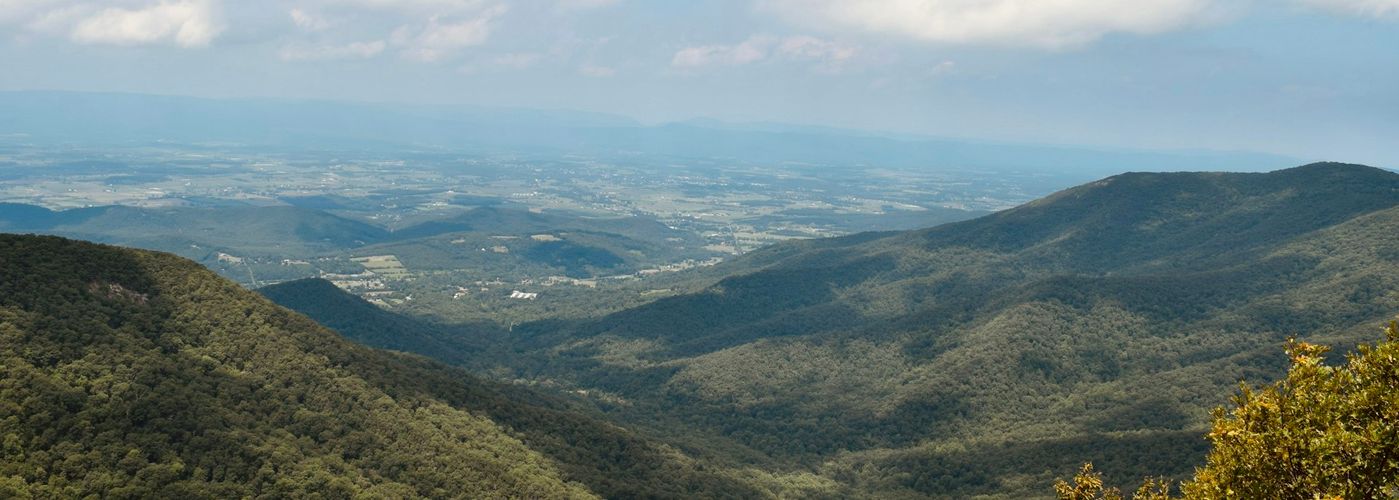 a view of a valley with mountains in the distance