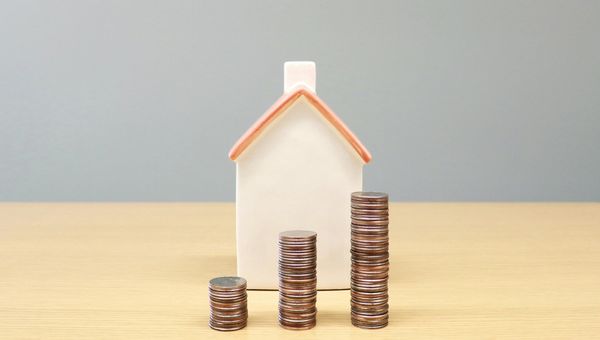 Home with stacked coins in front