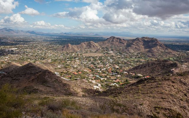 a view of a city and mountains from a hill