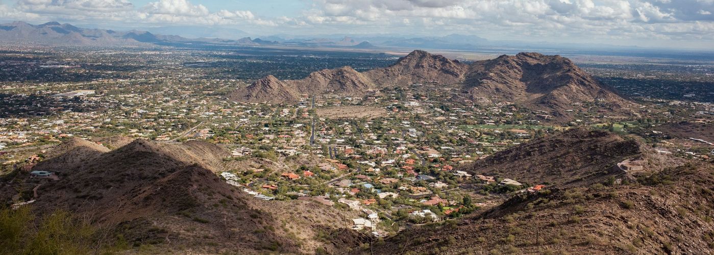 a view of a city and mountains from a hill