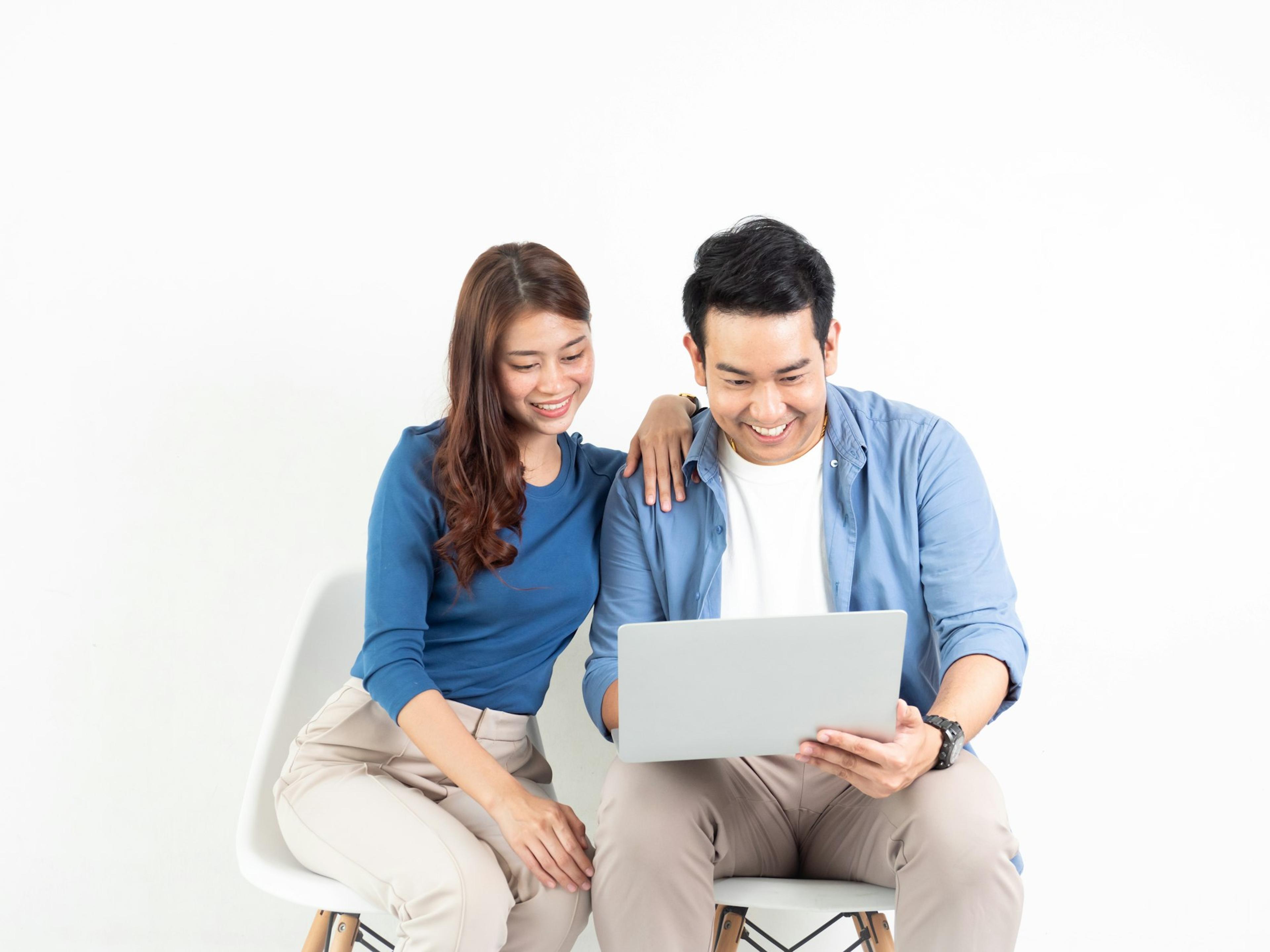 A couple sitting together looking at a laptop, planning at home