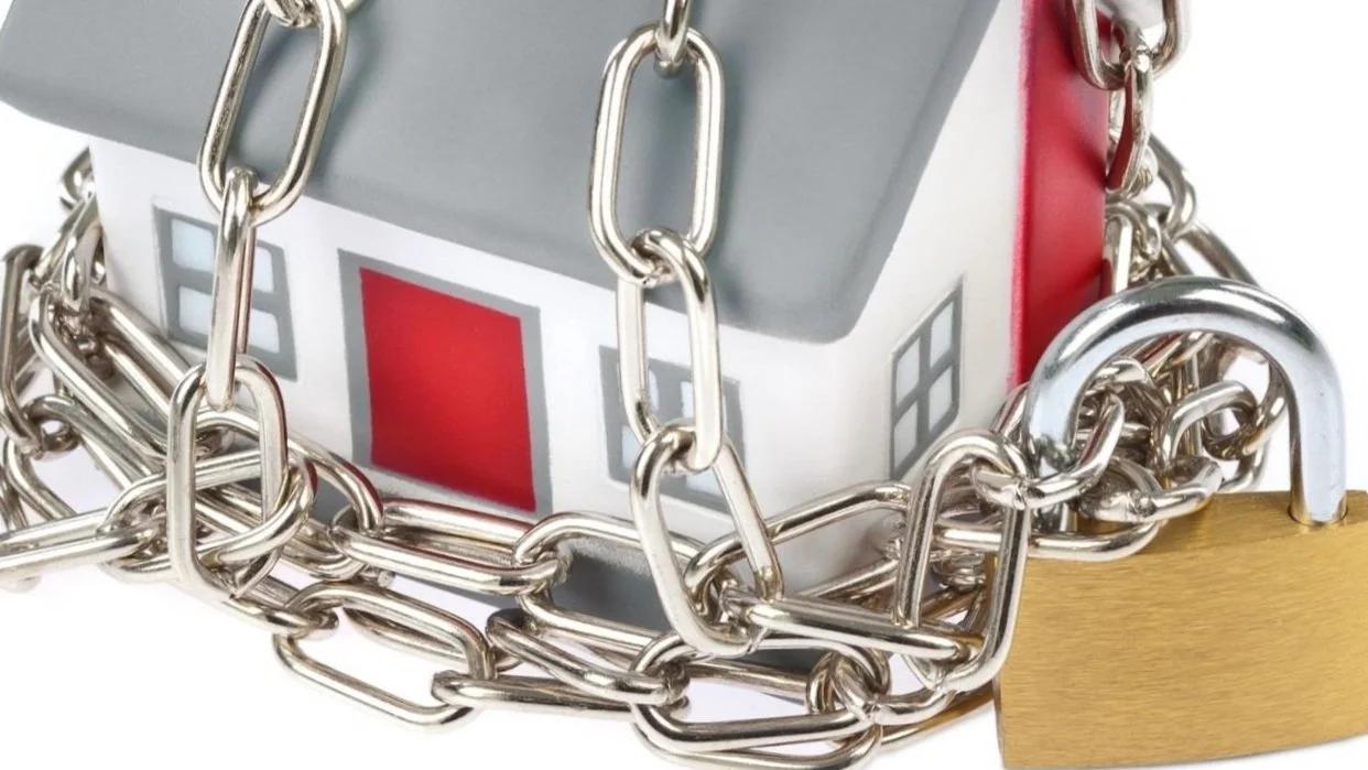 Model house wrapped in chains and a padlock: HDB ownership rules for permanent residents