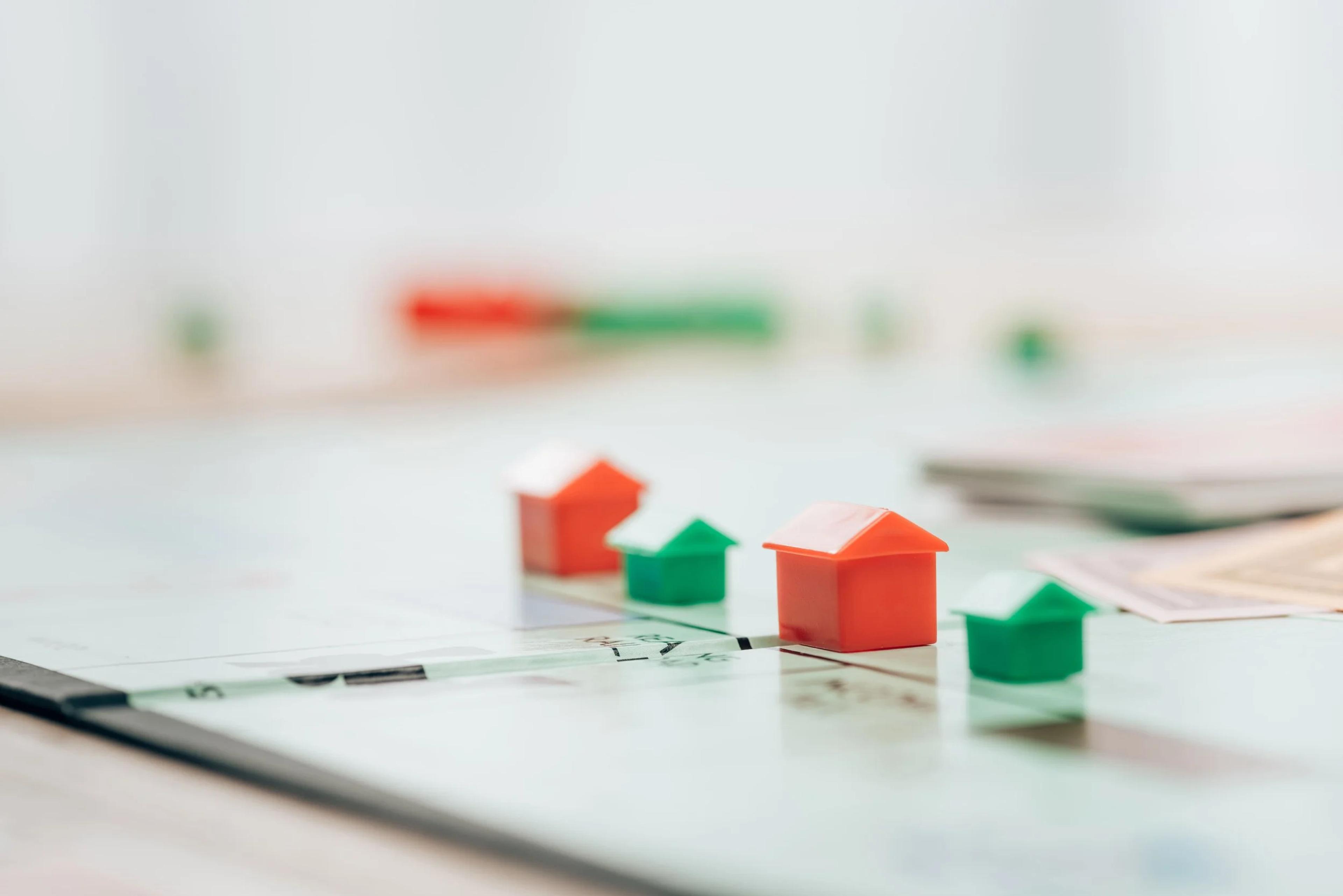 Red and green model houses on a property board game