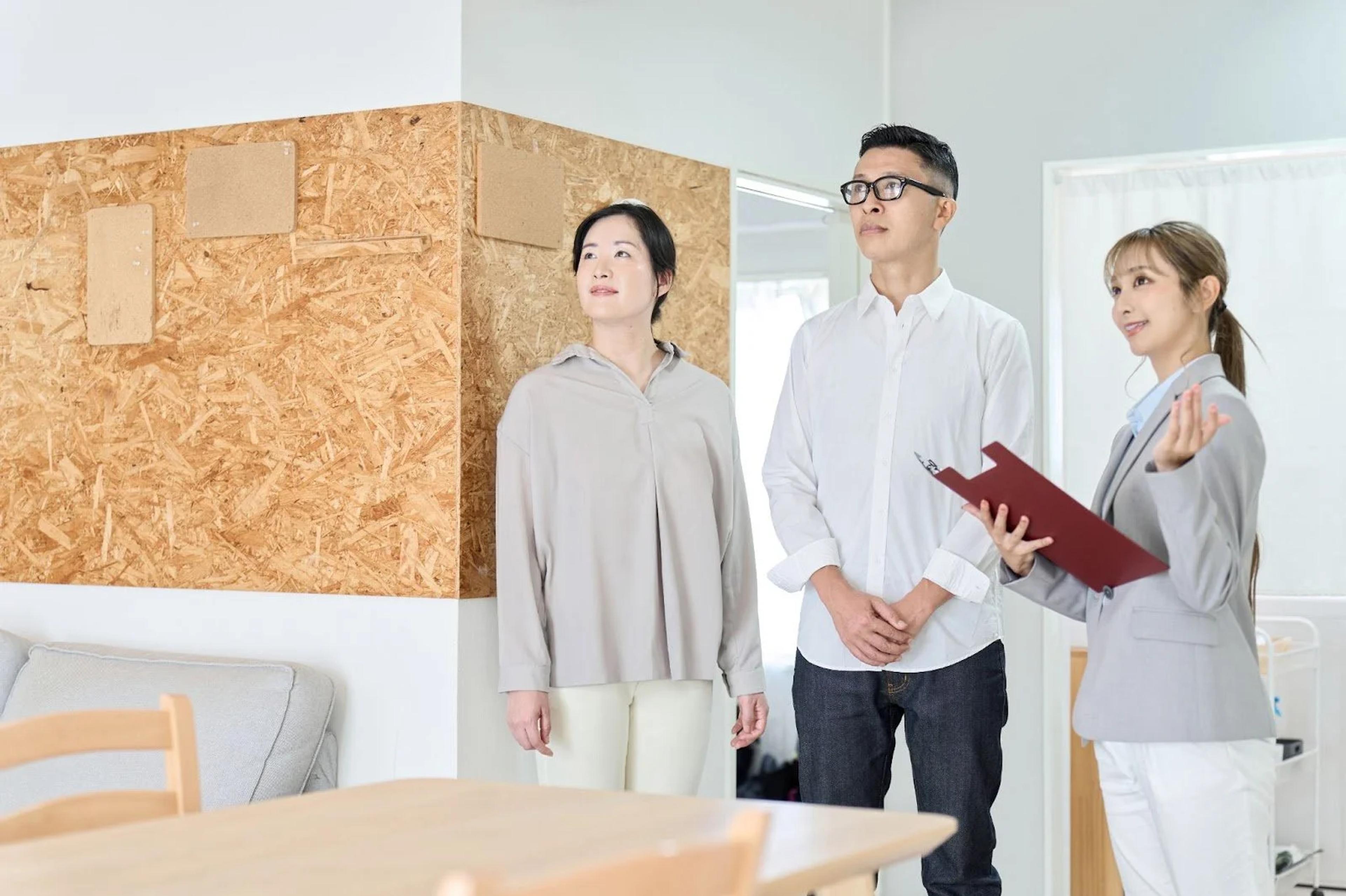 Property agent showing an Asian couple around a home for sale