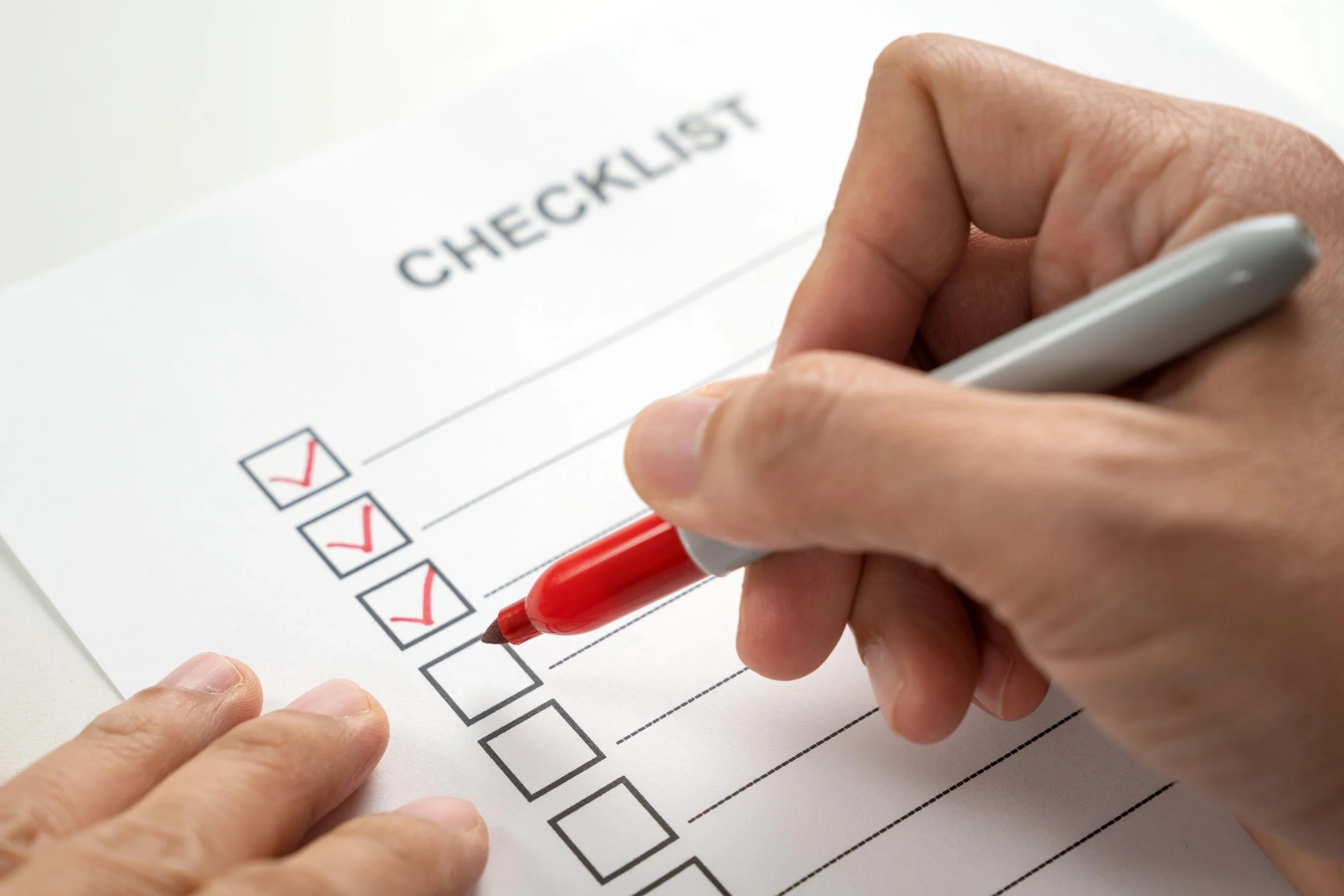 Ticking off a checklist with a red pen before selling a property
