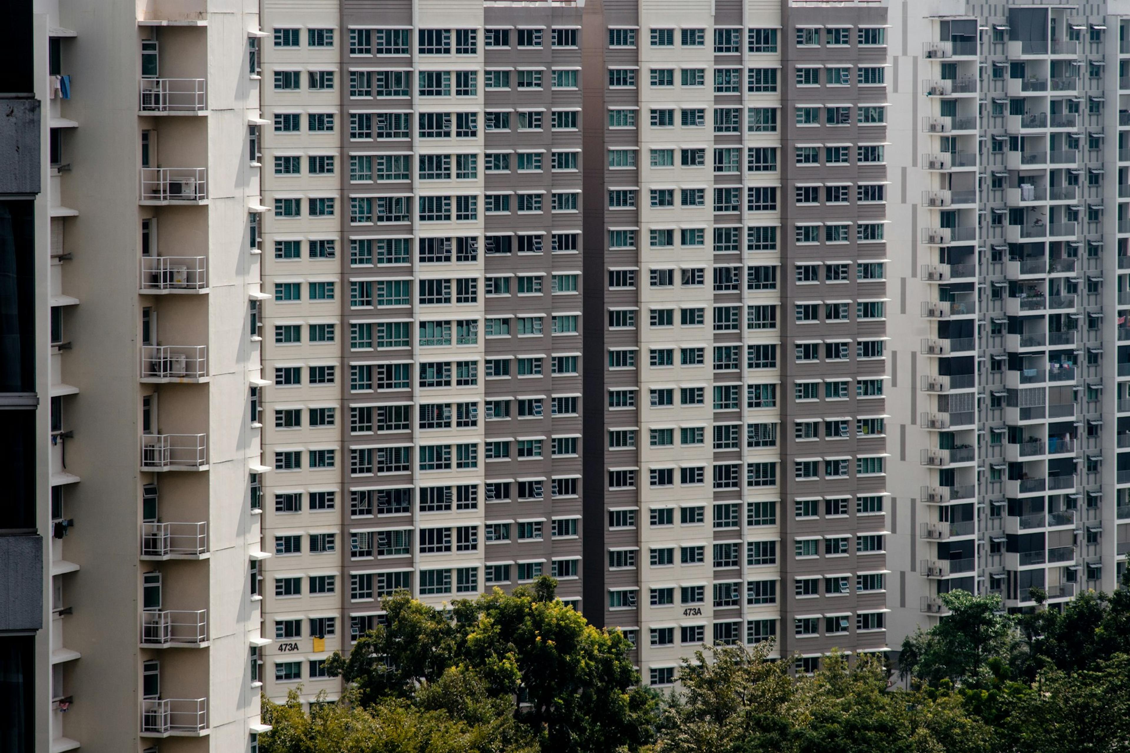 Facade of a high-rise HDB block with trees in front