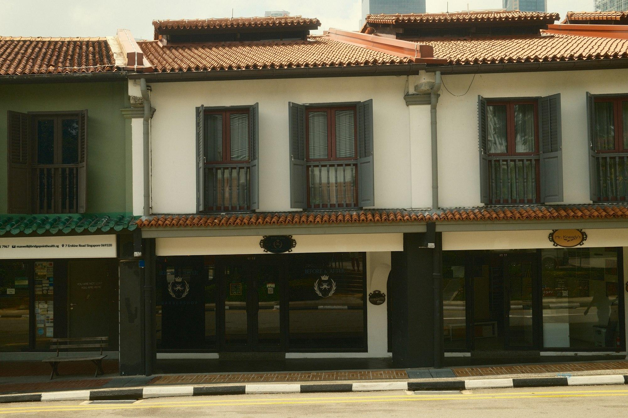 Traditional shophouses with terracotta tiled roofs and grey shutters in Singapore