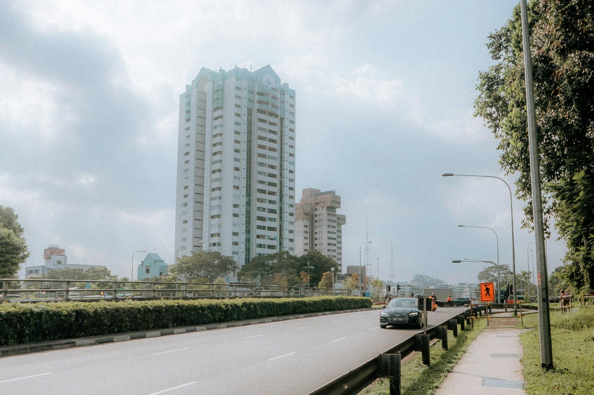 A car driving down a street next to tall buildings