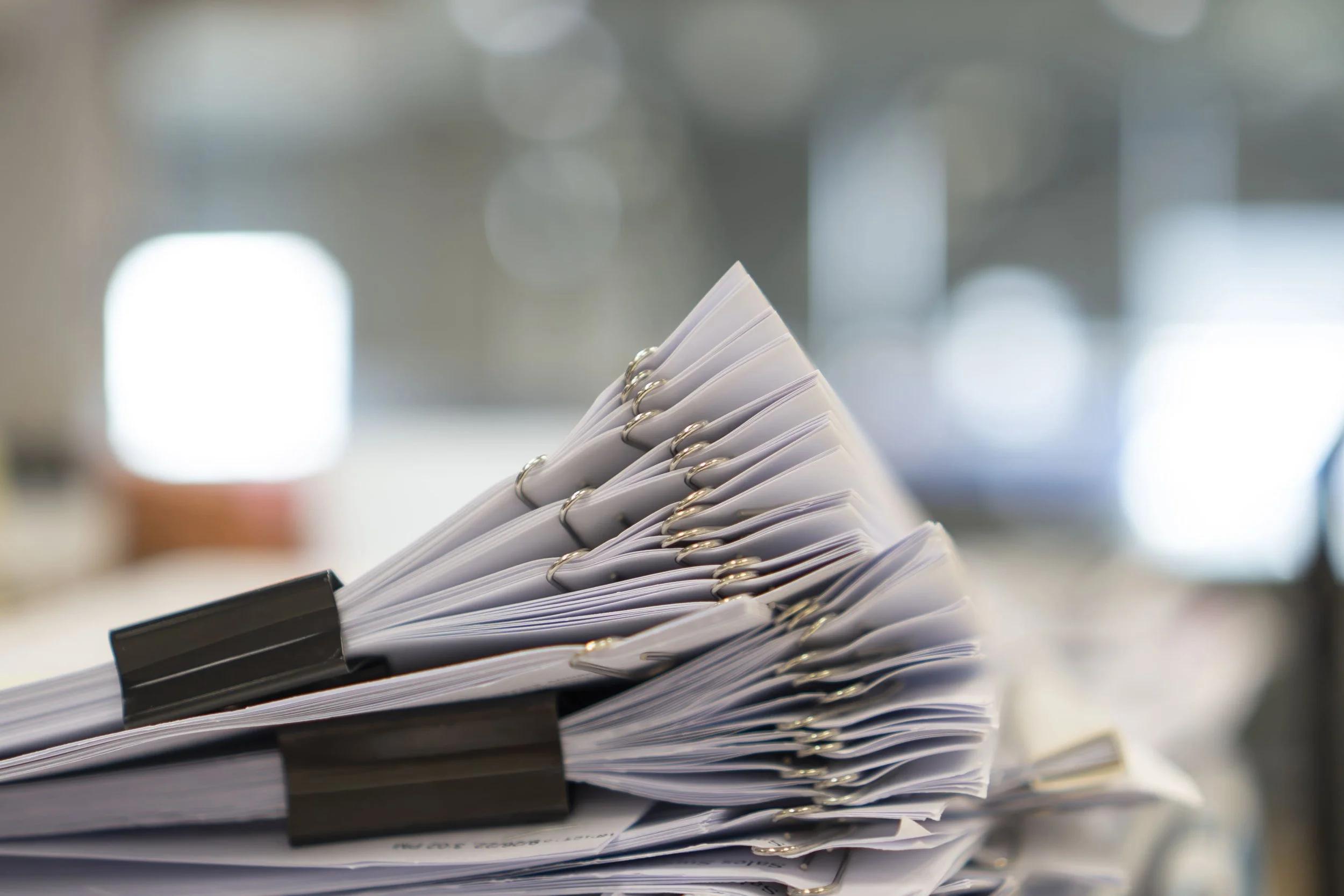 Stacks of property sale documents and paperwork on a desk