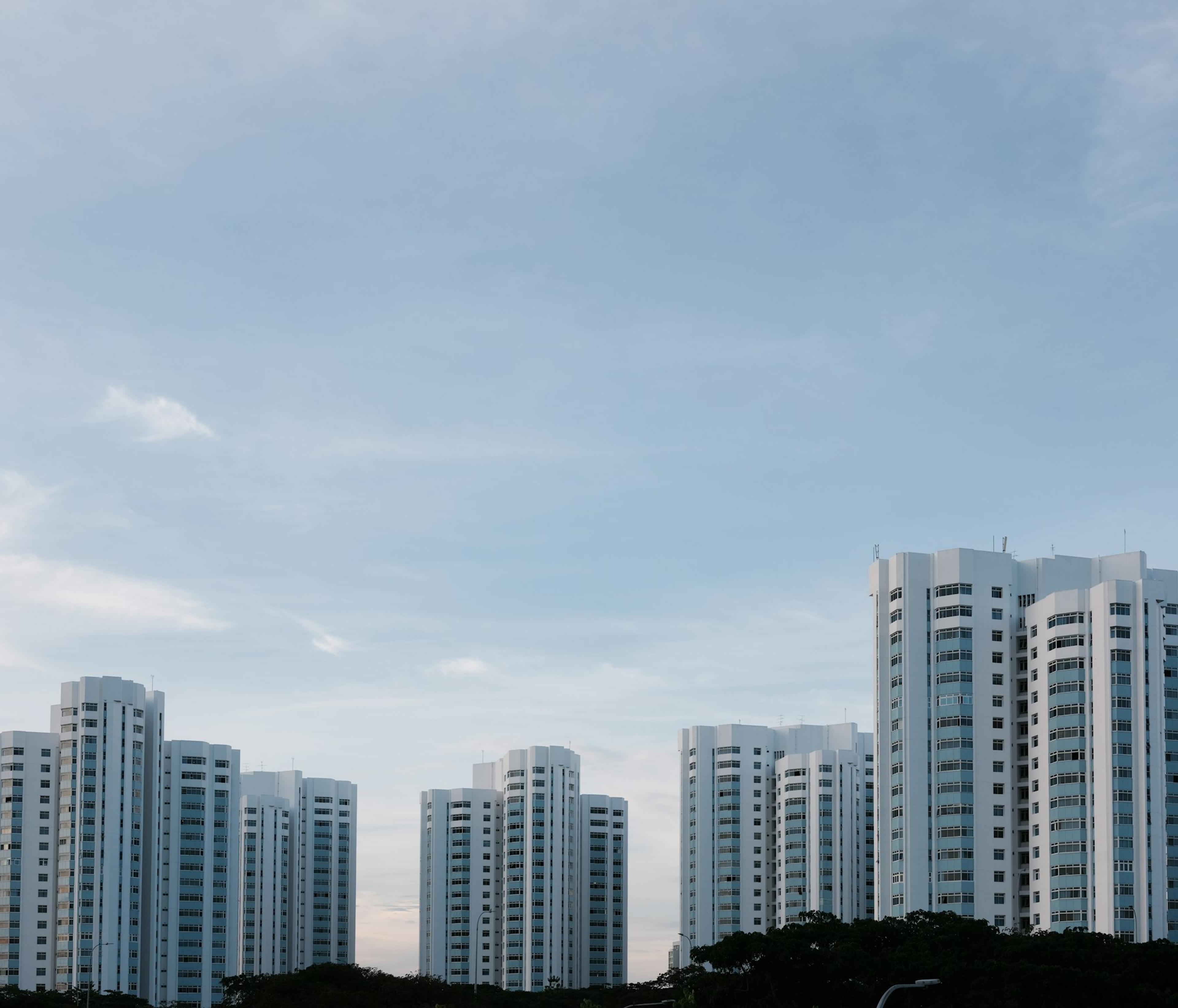 White HDB residential blocks under a blue sky in Singapore