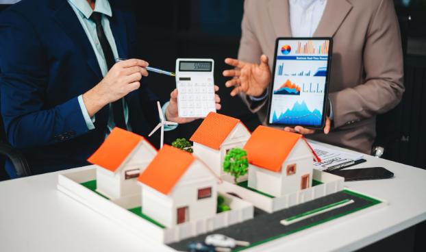 Advisers reviewing a housing development model with a calculator and investment charts