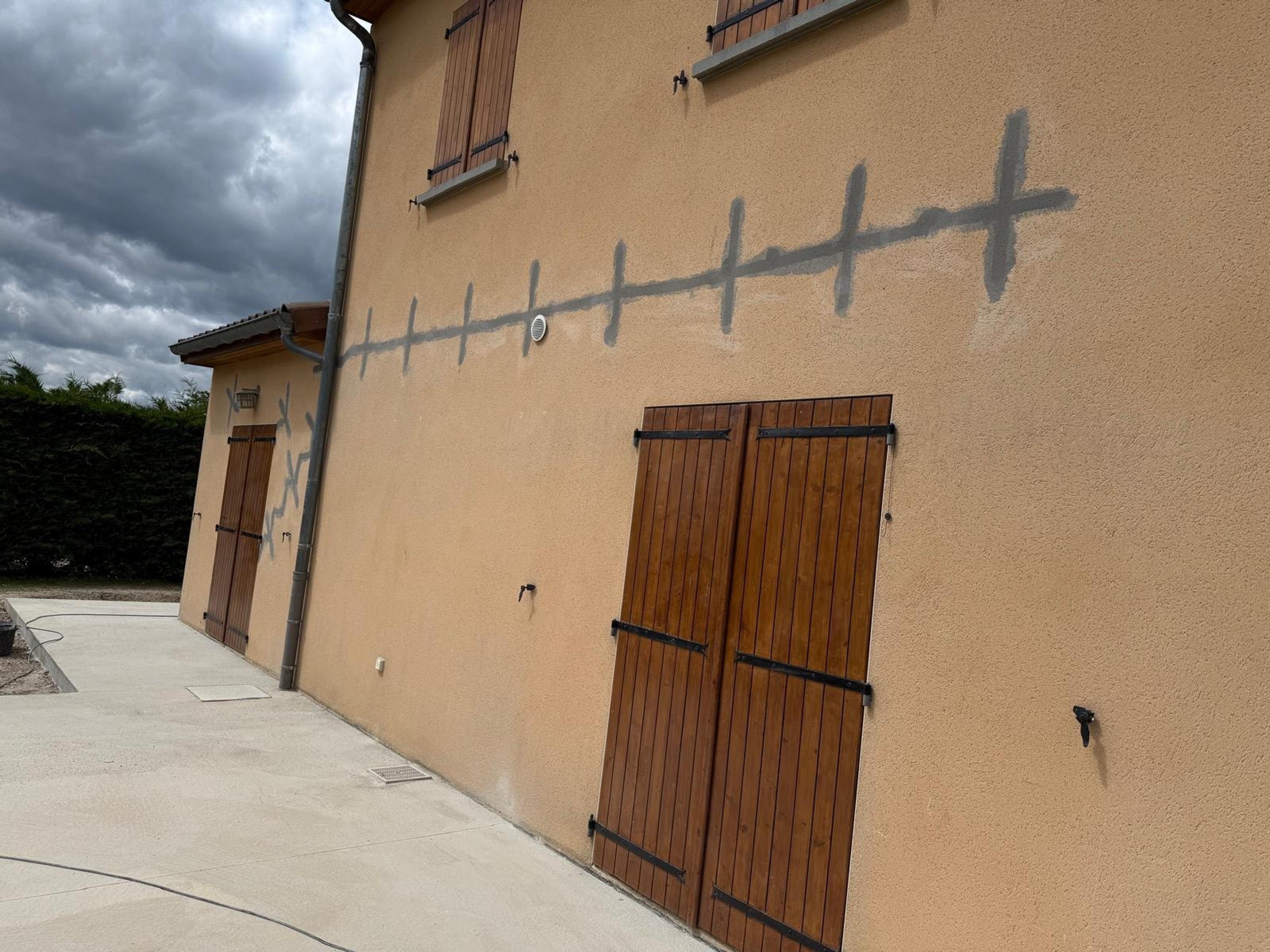 Façade enduite aux volets bois, fissure agrafée sur toute sa longueur