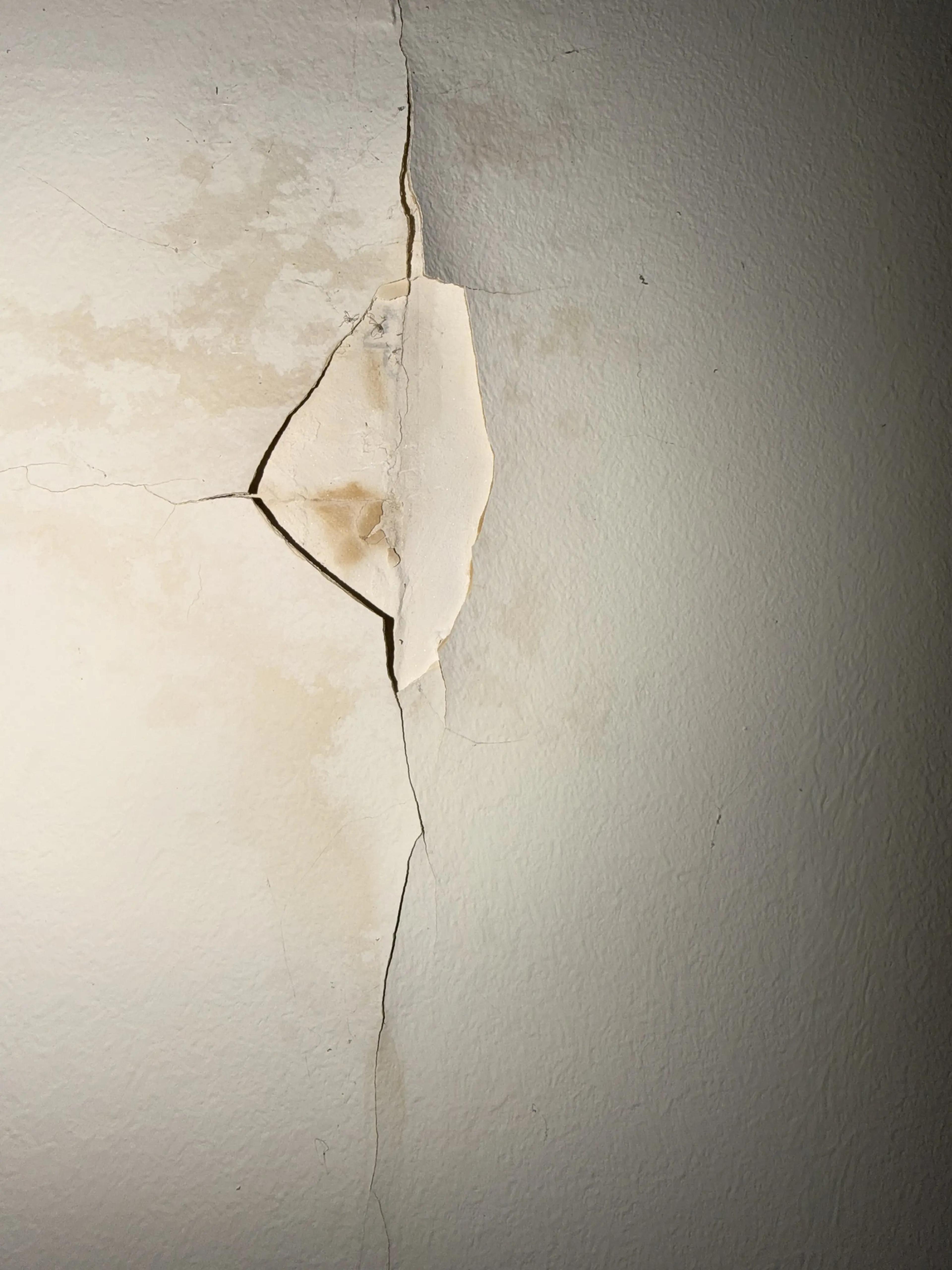 Fissure et peinture décollée sur un mur