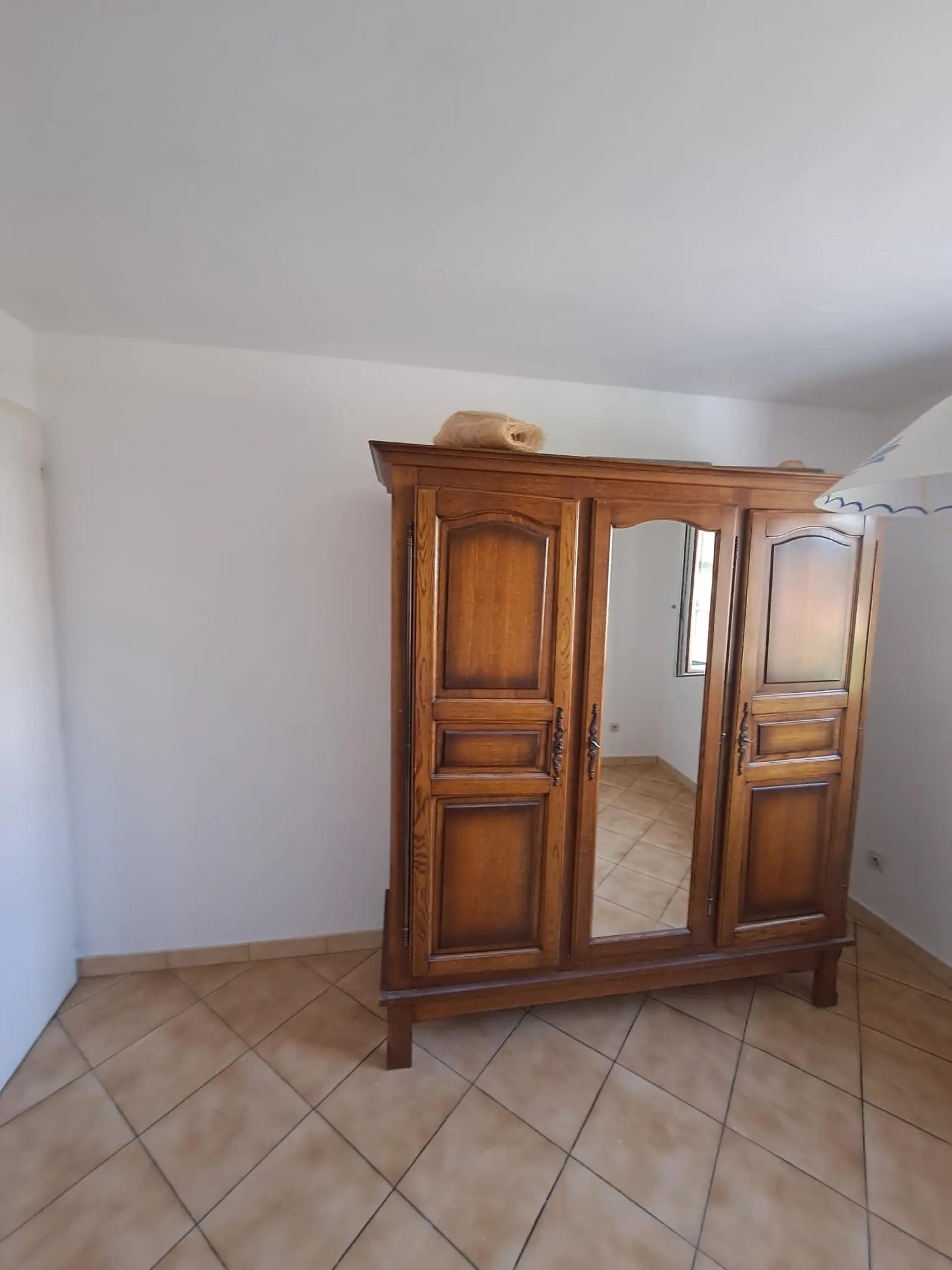 La chambre après travaux : murs repeints, armoire en bois
