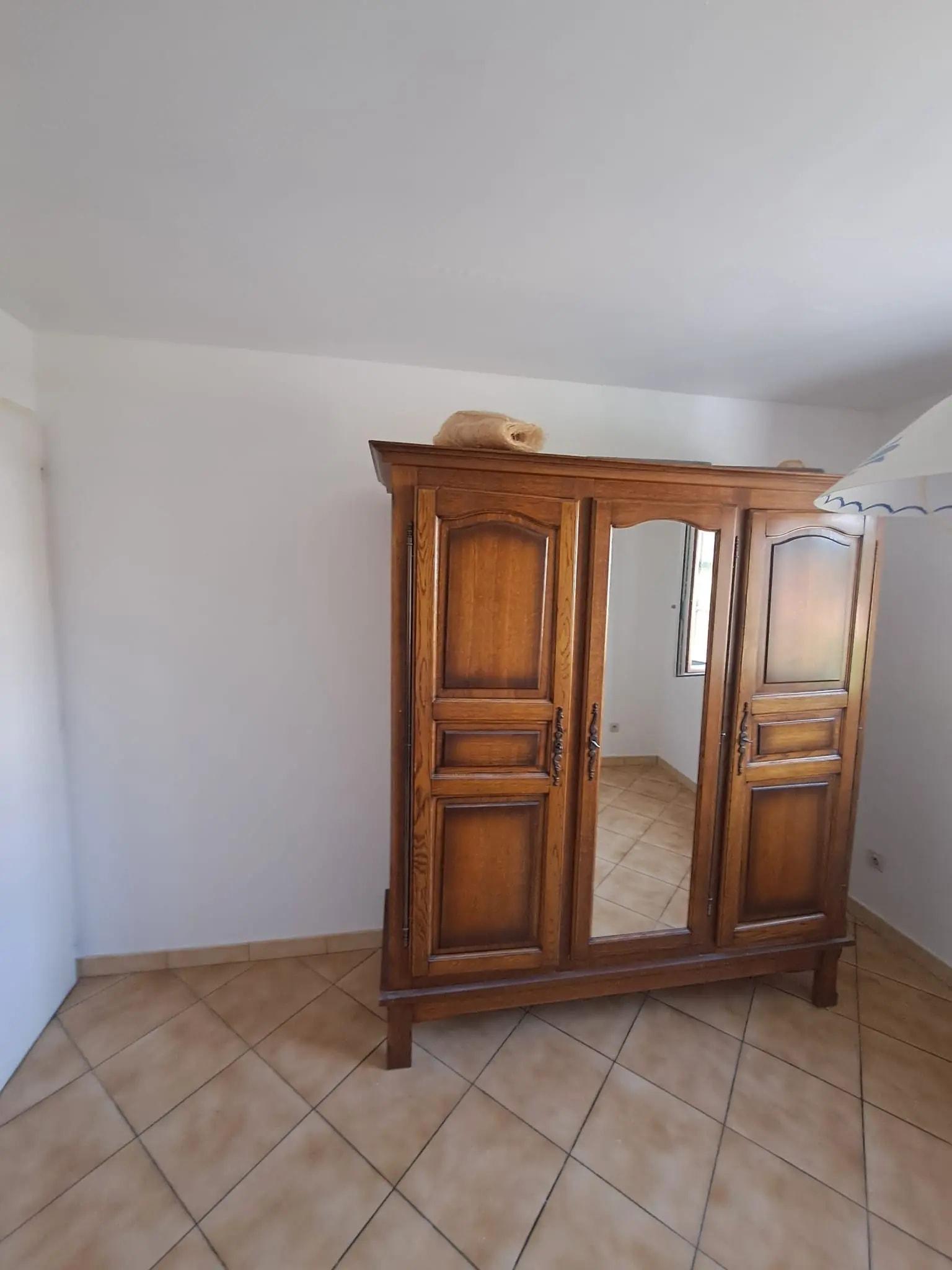 La chambre après travaux : murs repeints, armoire en bois