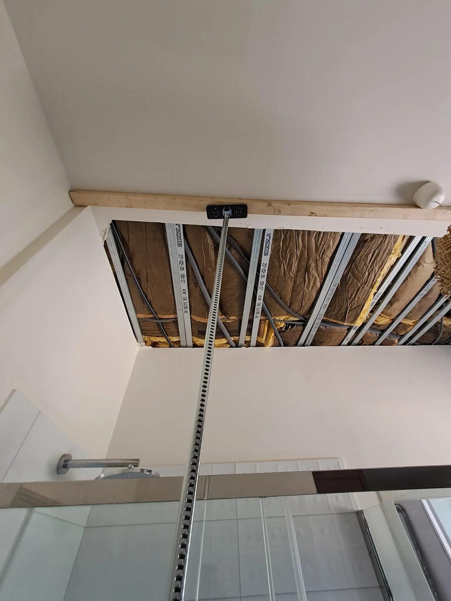Plafond ouvert : ossature métallique et isolant visibles