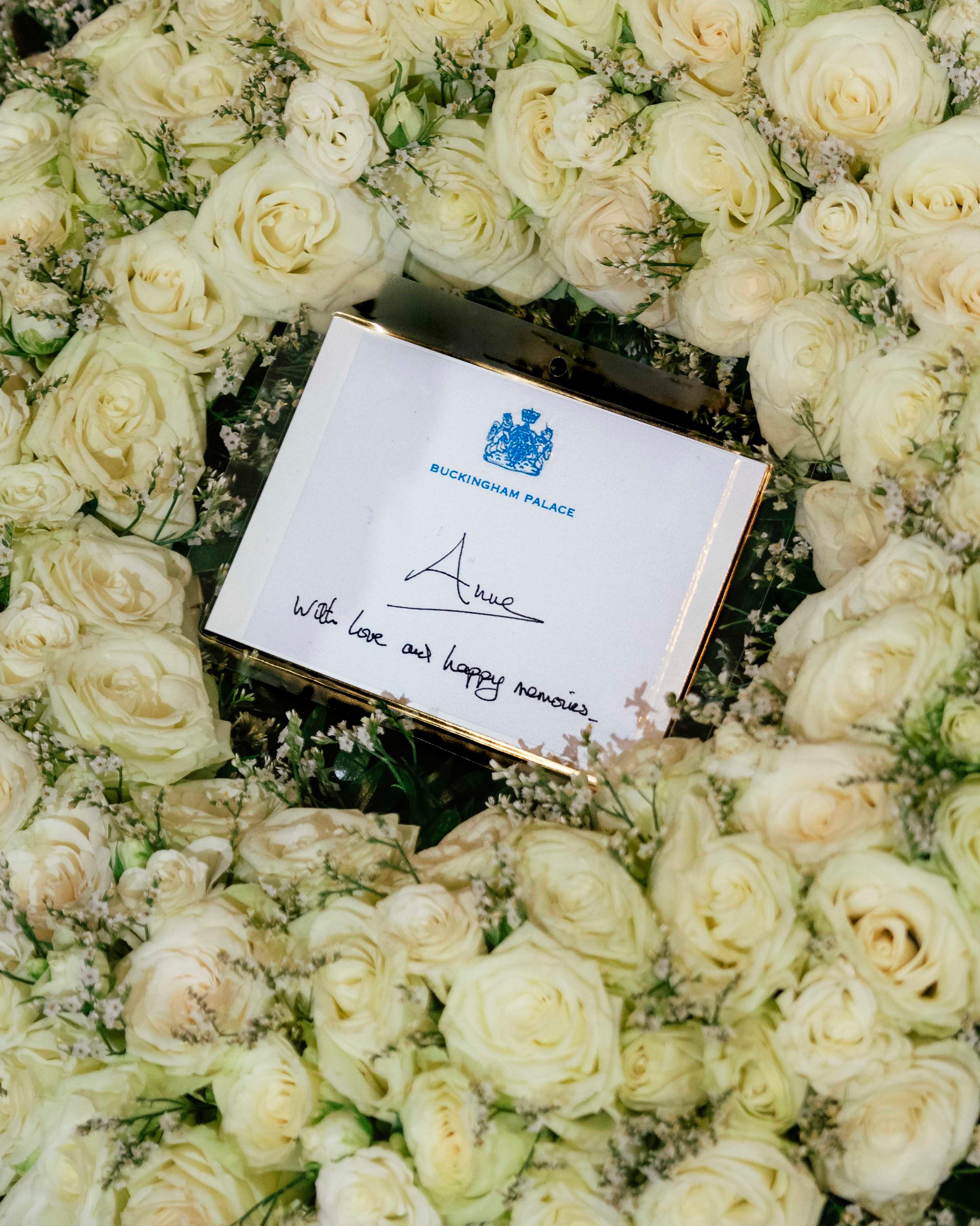 Hvit blomsterkrans med hilsen fra Anne - Princess Royal - hvor det står: with love and happy memories.