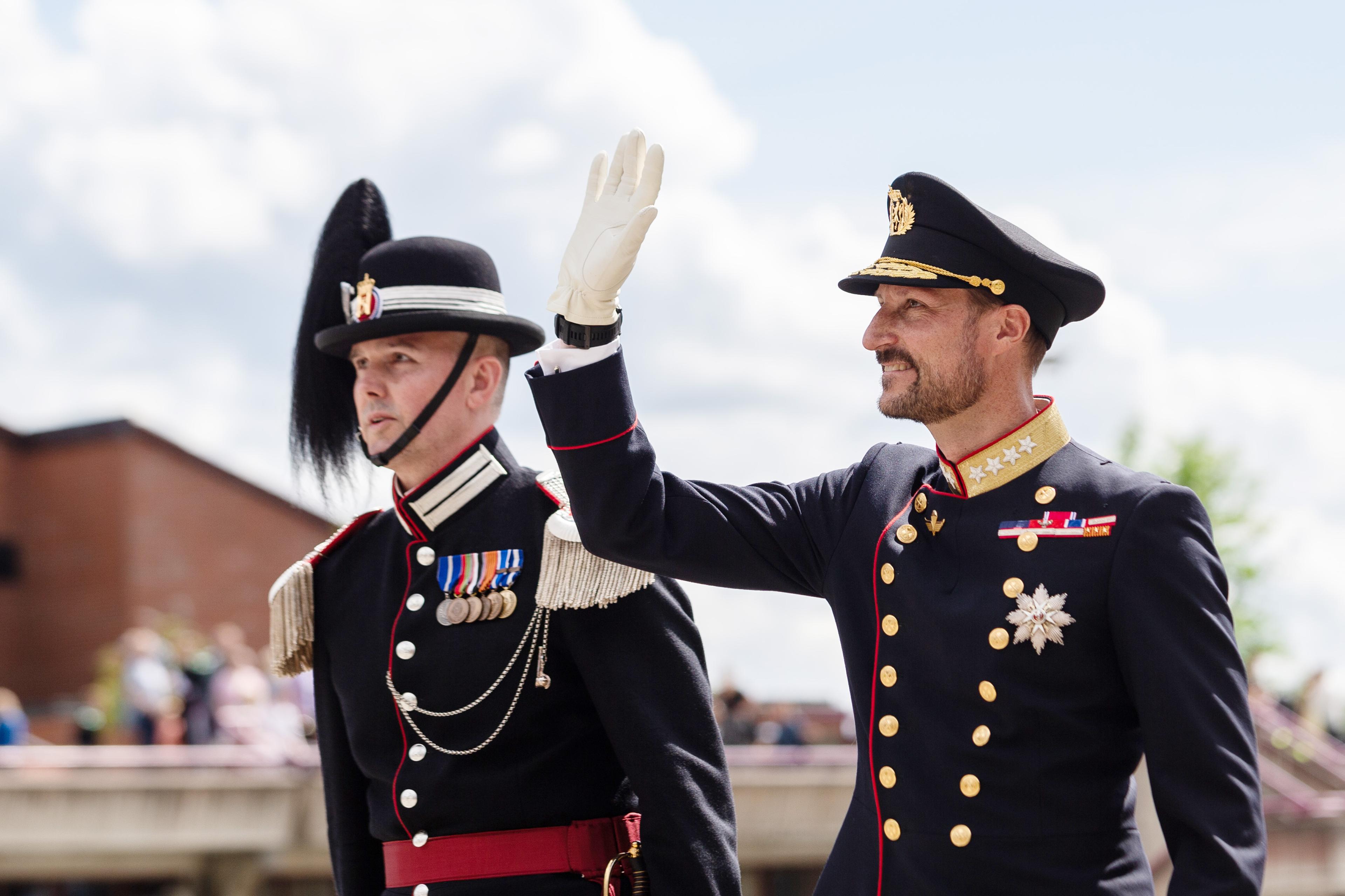 Kronprins Haakon vinker til tilskuere.