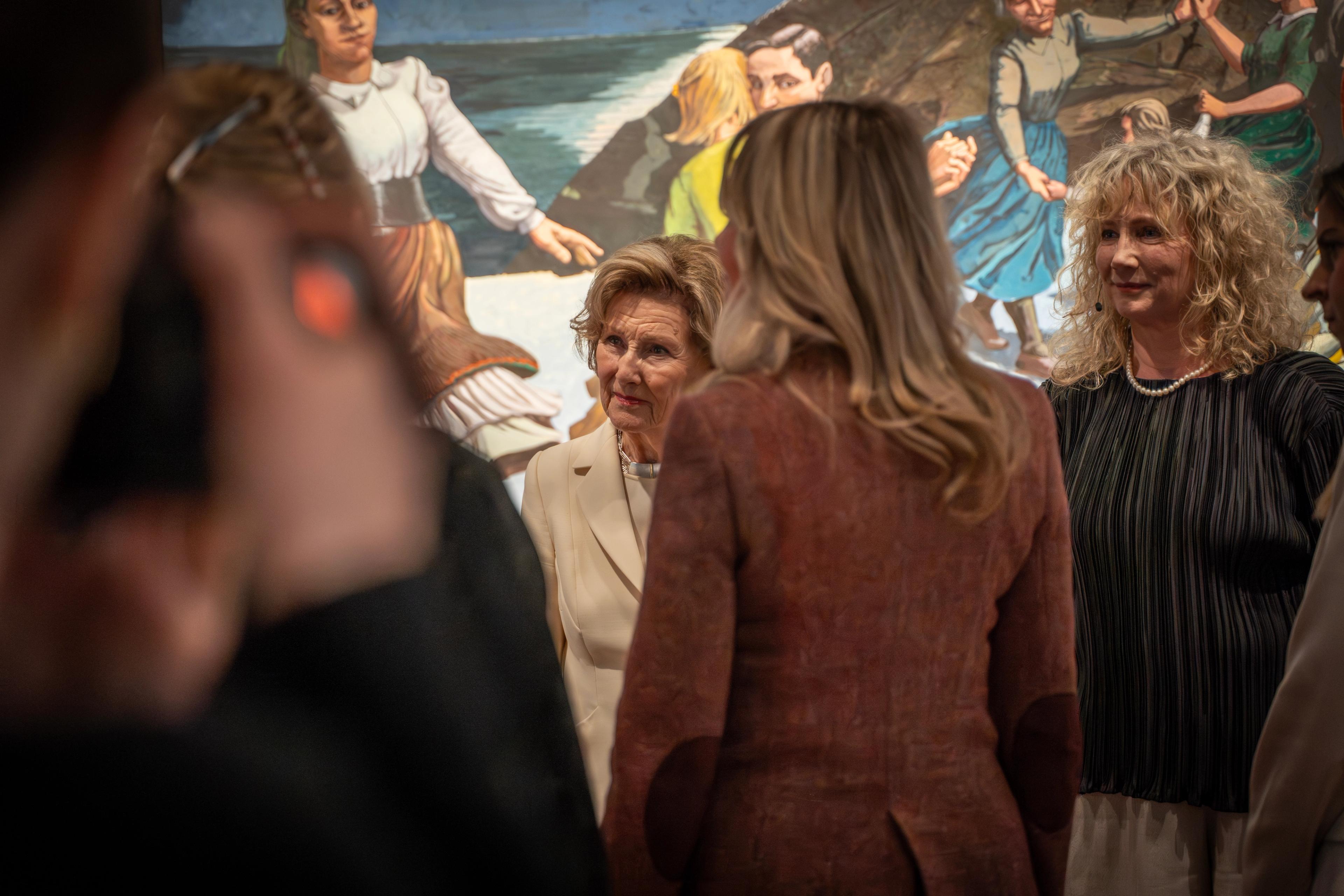 Dronning Sonja samtaler i ring med flere personer. Regos verk "Dansen" syns i bakgrunnen.