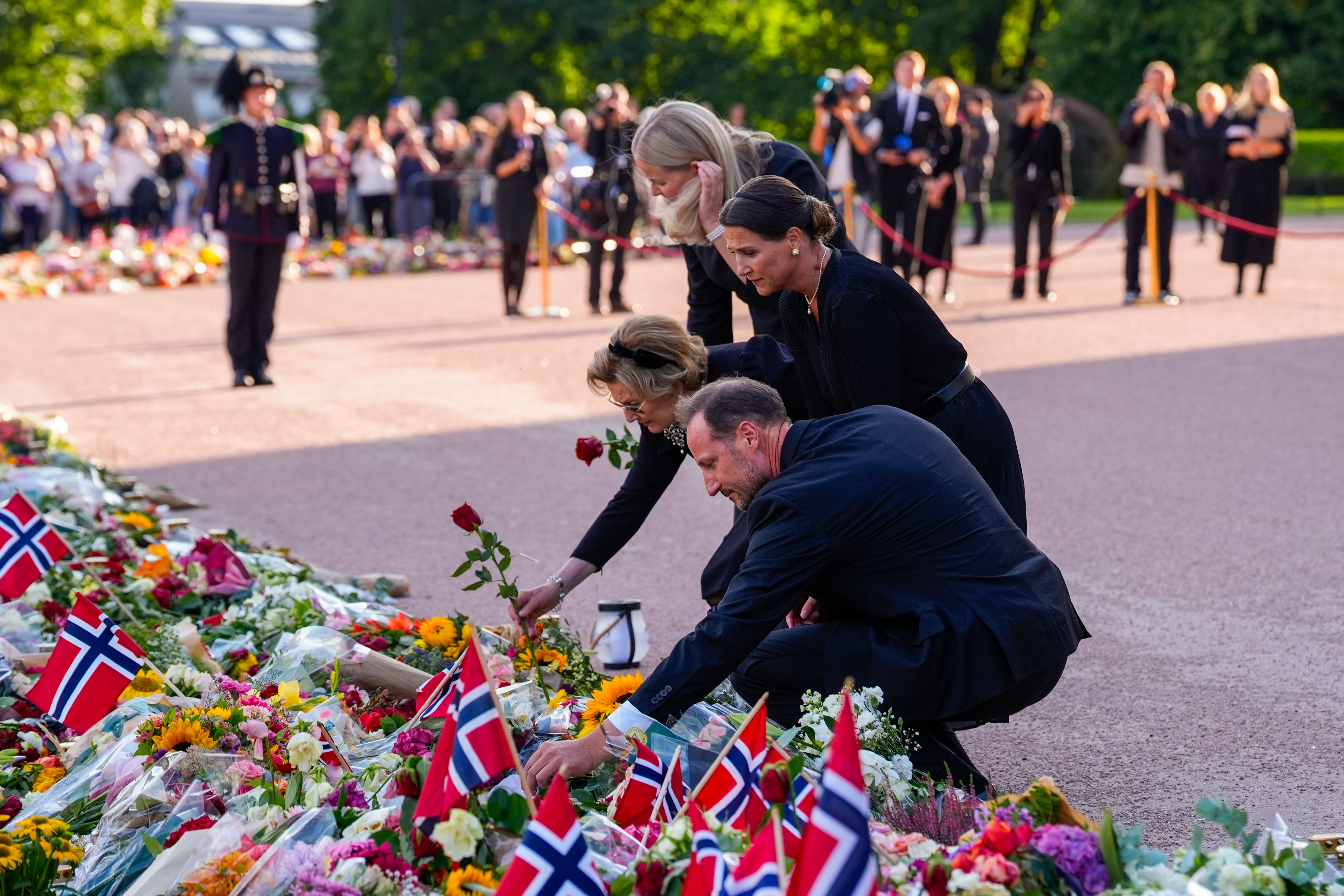 Kong Haakon, Dronning Mette-Marit, Dronning Sonja og Prinsesse Märtha Louise legger ned roser i blomsterhavet.