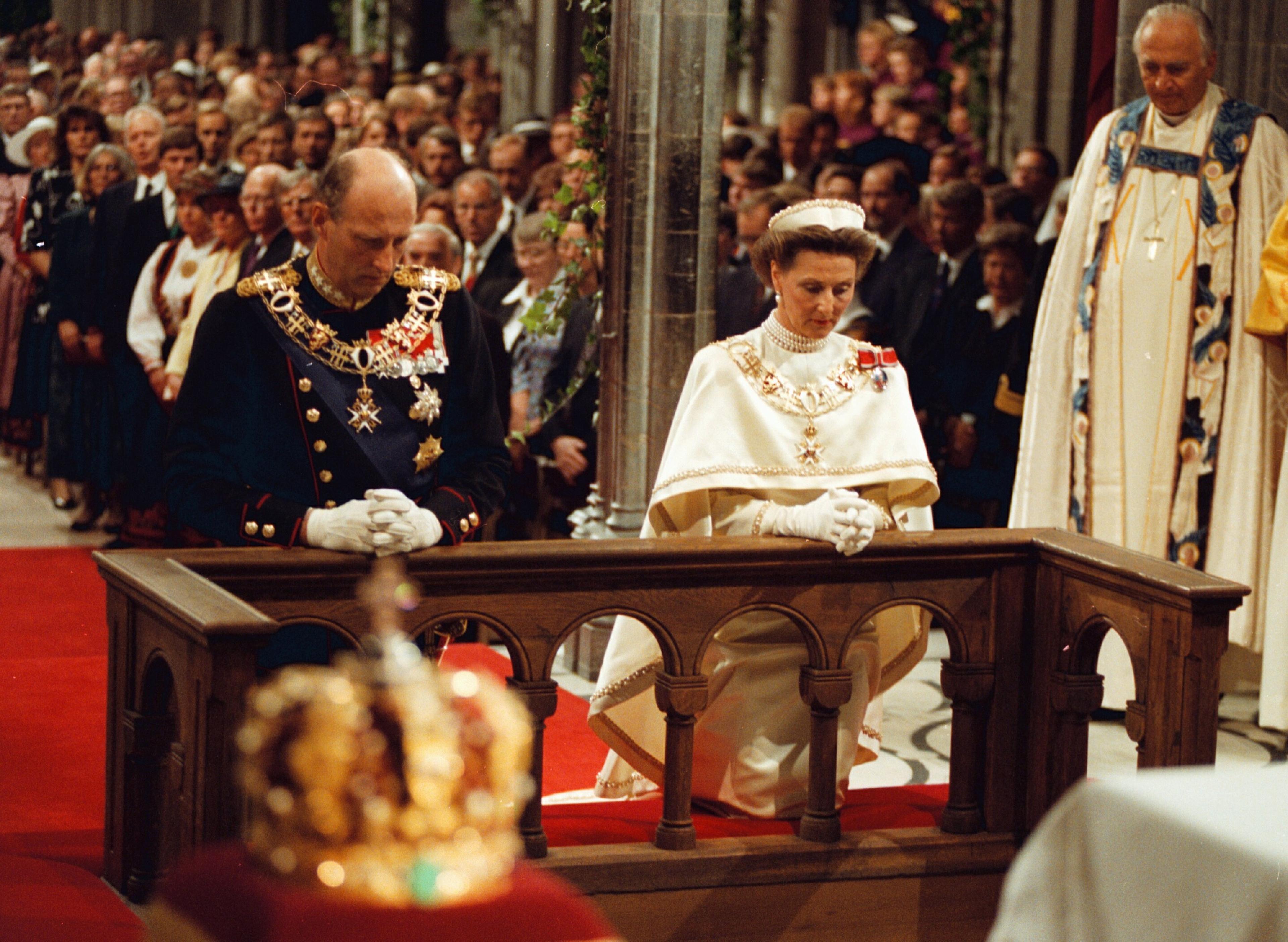 Kongeparet sitter på knær foran alteret i Nidarosdomen